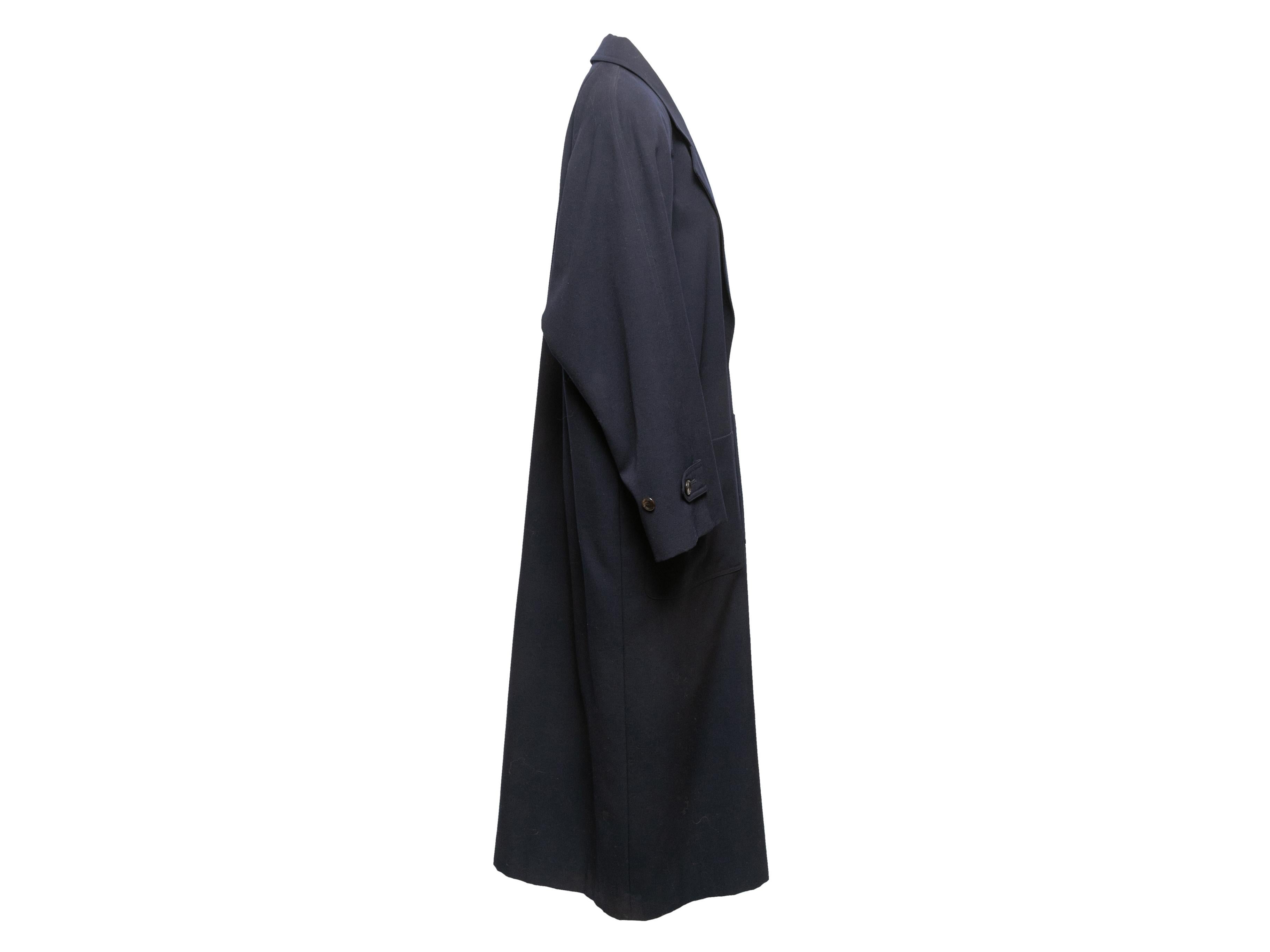 Navy long wool coat by Fashion House Sanyo. Notched lapel. Dual patch pockets at hips. Front button closures. 46