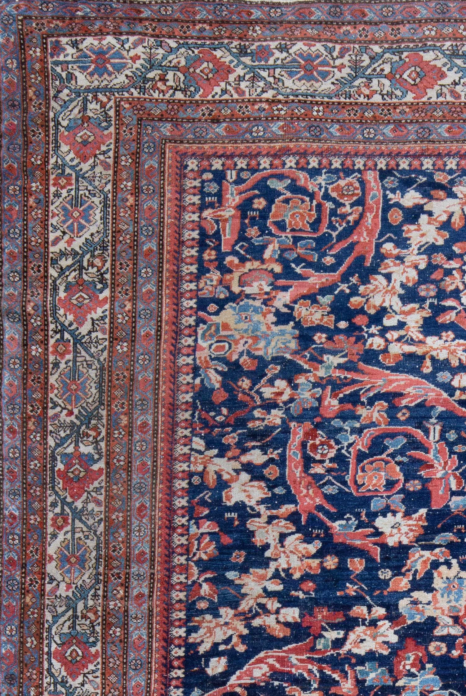 An unusual Ferahan with a rich navy field and vibrant all over floral design in light madder red, pink, coral, cornflower blue and jade green. A naturally dyed, turn of the century carpet with an even, low wool pile. Sides and ends preserved. A