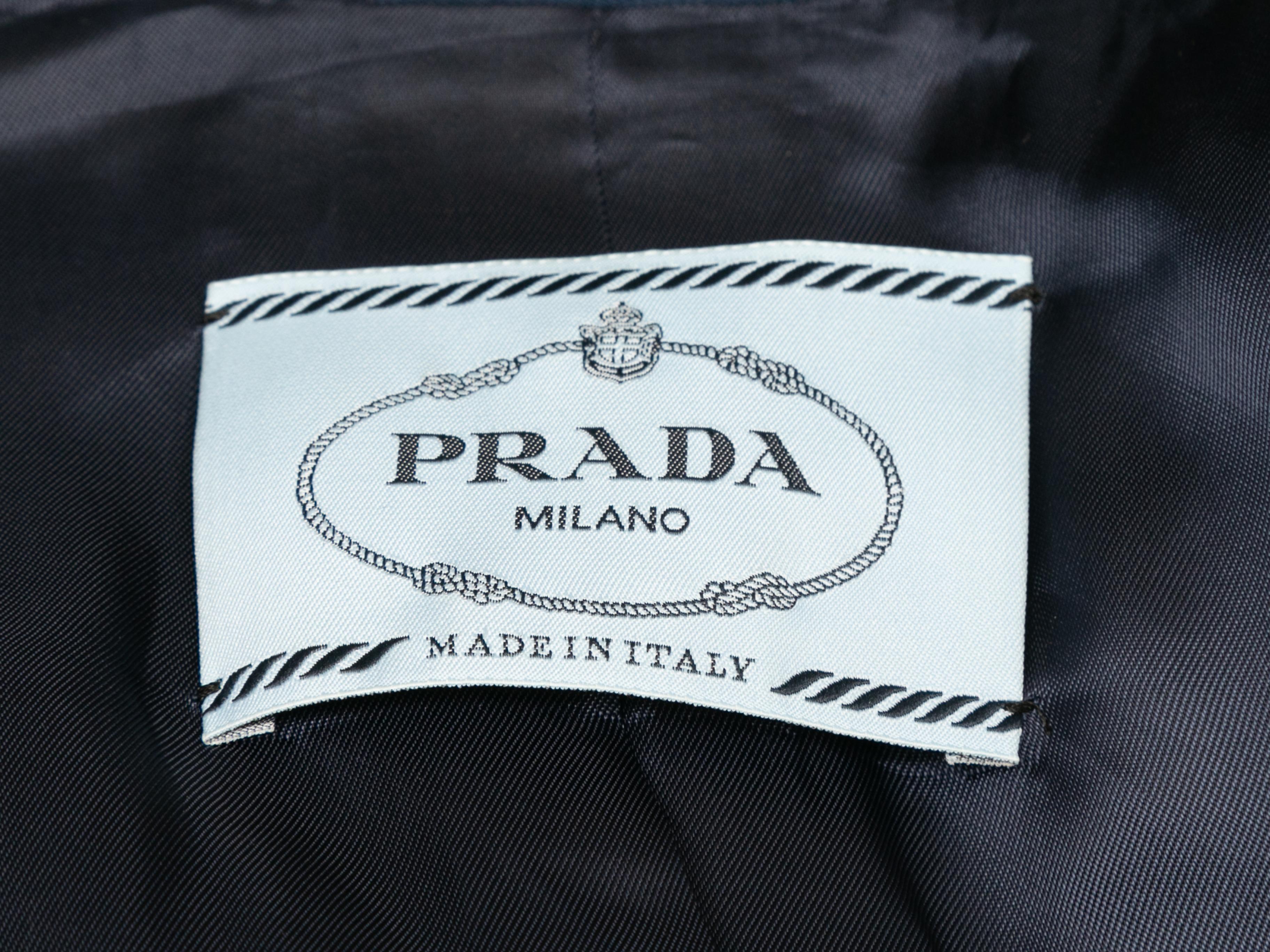 Navy 2018 rubber detail blazer by Prada. Notched lapel. Three pockets. Rubber logo accent at front button closures. 34