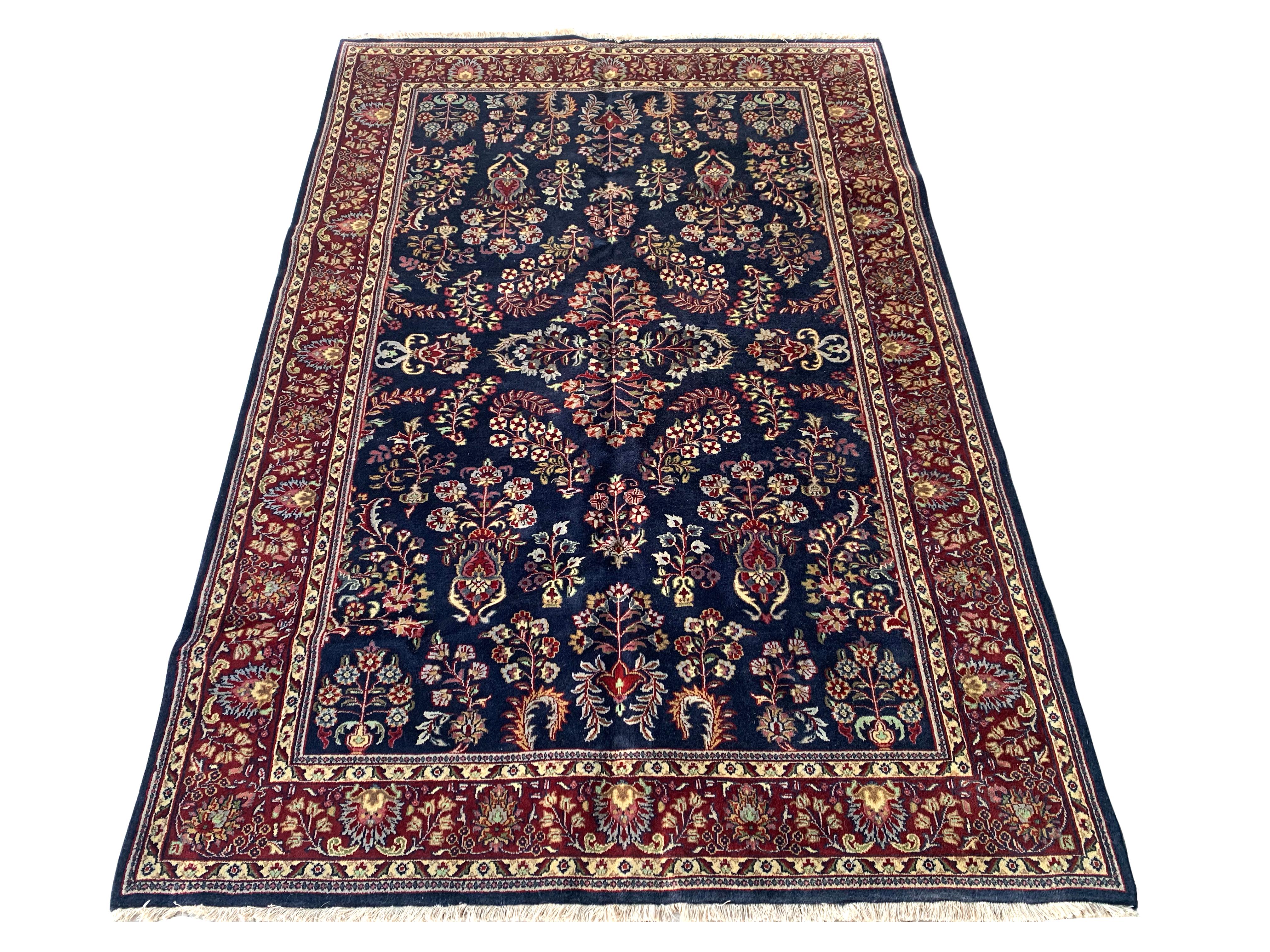 Handgeknüpfter Wollflor auf einem Baumwollgrund.

Neu

Abmessungen: 6' x 9'

Herkunft: Indien

Zustand: Ausgezeichnet

Feldfarbe: Marineblau

Farbe der Umrandung: Kirsche-Rot

Akzentfarben: Elfenbein, Grau, Gold, Hell-Gold