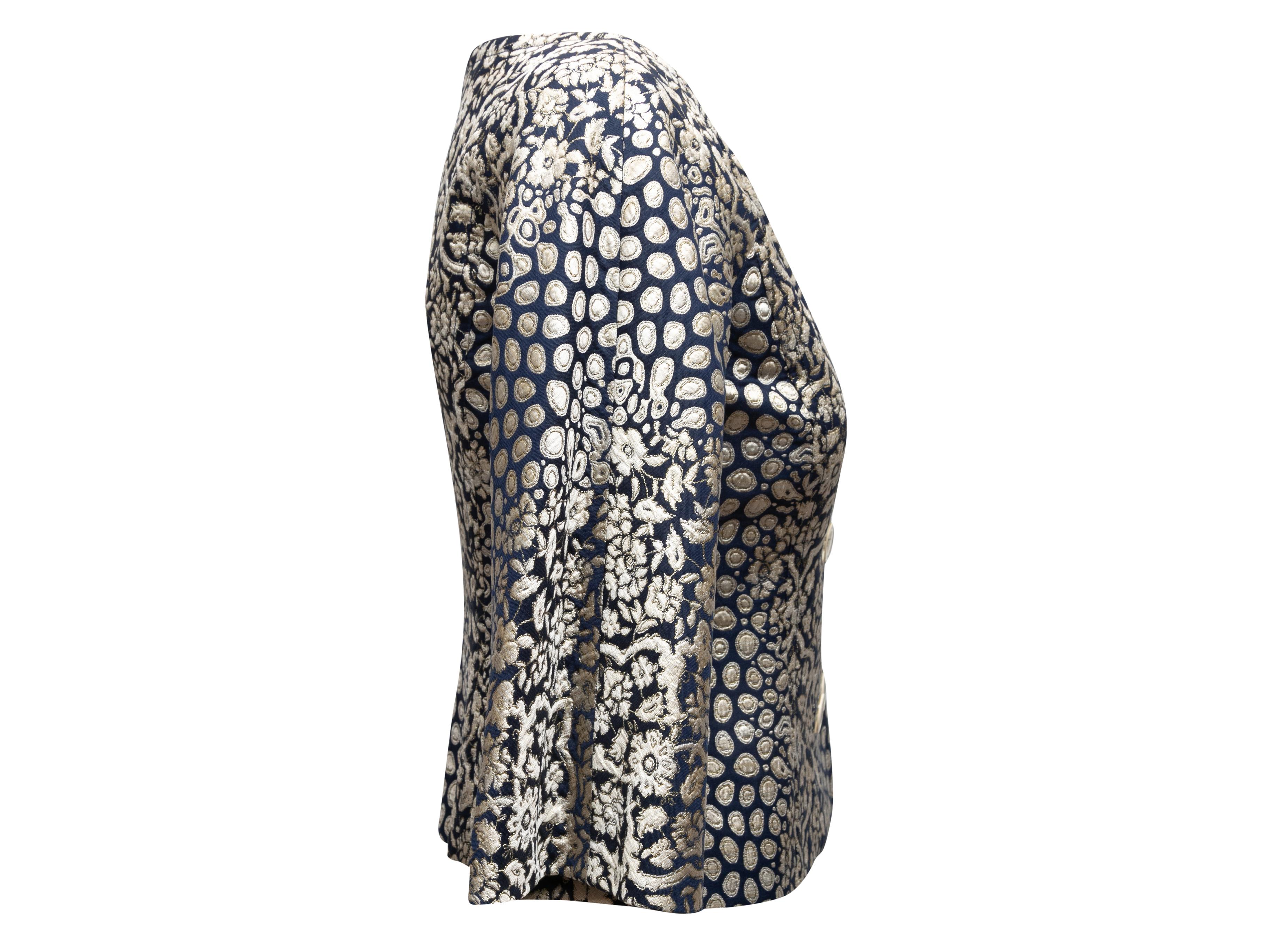 Navy and silver metallic jacquard patterned evening jacket by Carolina Herrera. Scoop neckline. Cropped sleeves. Double-breasted button closures at front. 28
