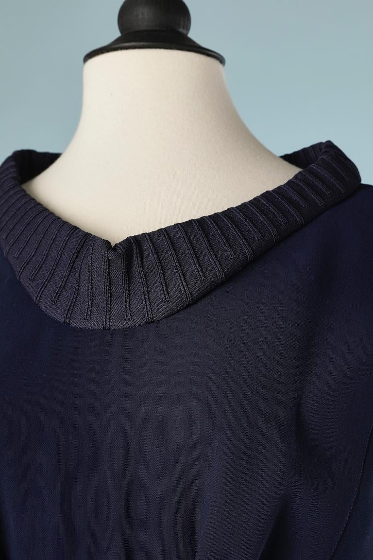 Navy sleeveless jumpsuit with knit collar and waist. Fabric composition: 6% rayon, 20% polyester, 16% polyamide. Lining: 100% polyester. 
SIZE 40 (M) 