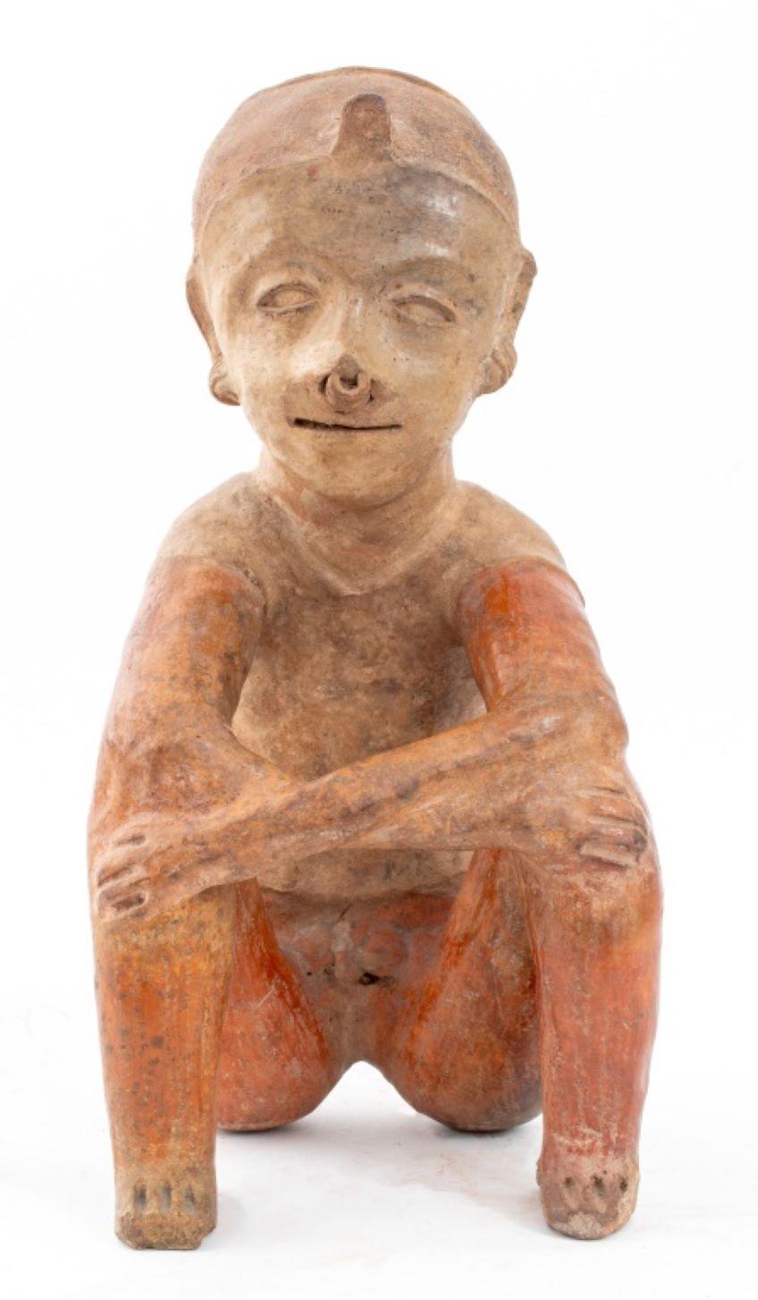 Figure masculine assise Pre-Columbian, représentant un homme avec une coiffe, des boucles d'oreilles et des anneaux de nez. 15.75