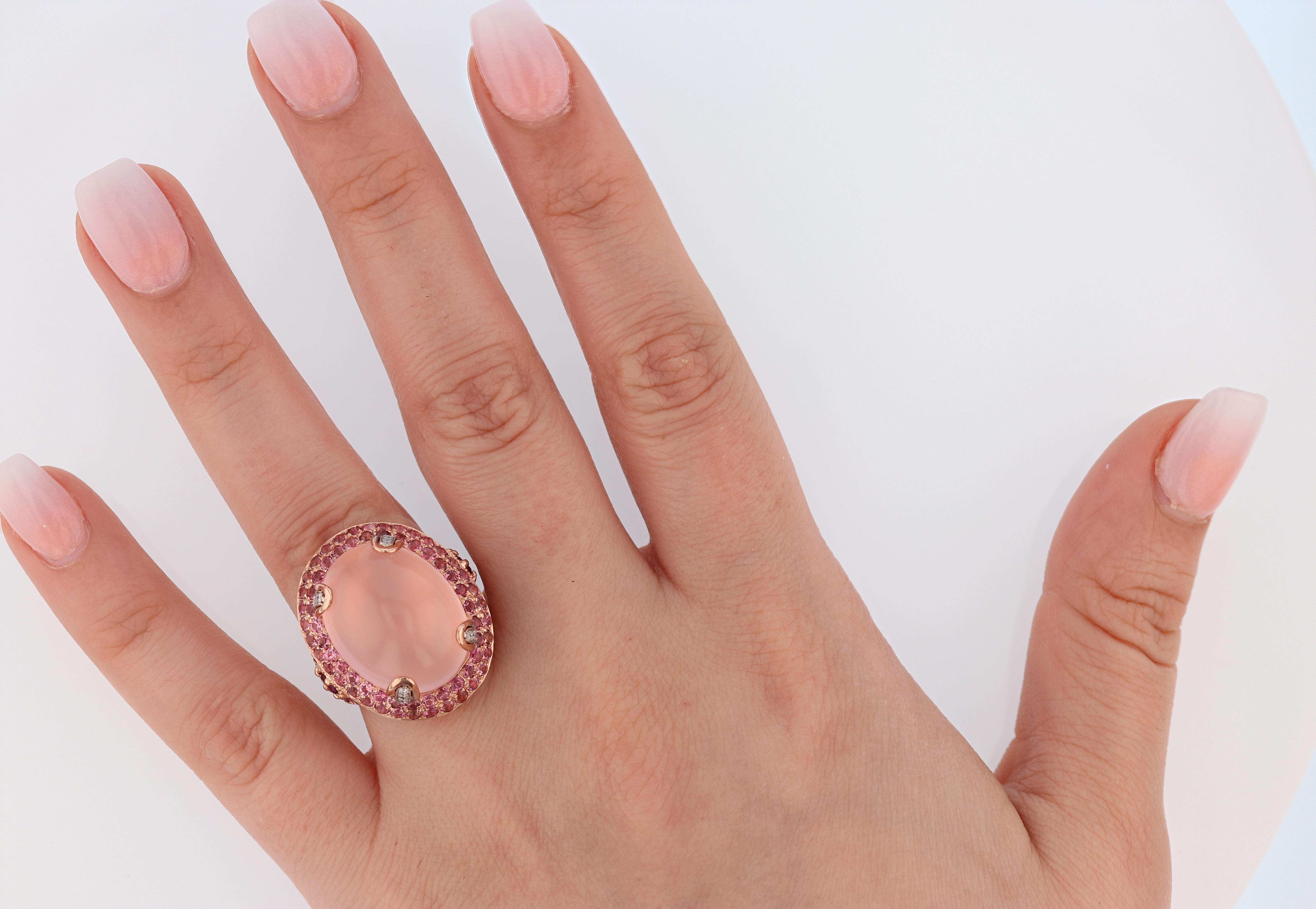 This ring is made in 14k rose gold featuring one 19.5 x 15 MM rose quartz and 2 prong set garnets weighing 0.33ct. Also this ring features 120 pave set round cut pink tourmaline on the halo and split shank. There are 12 round cut diamonds pave set