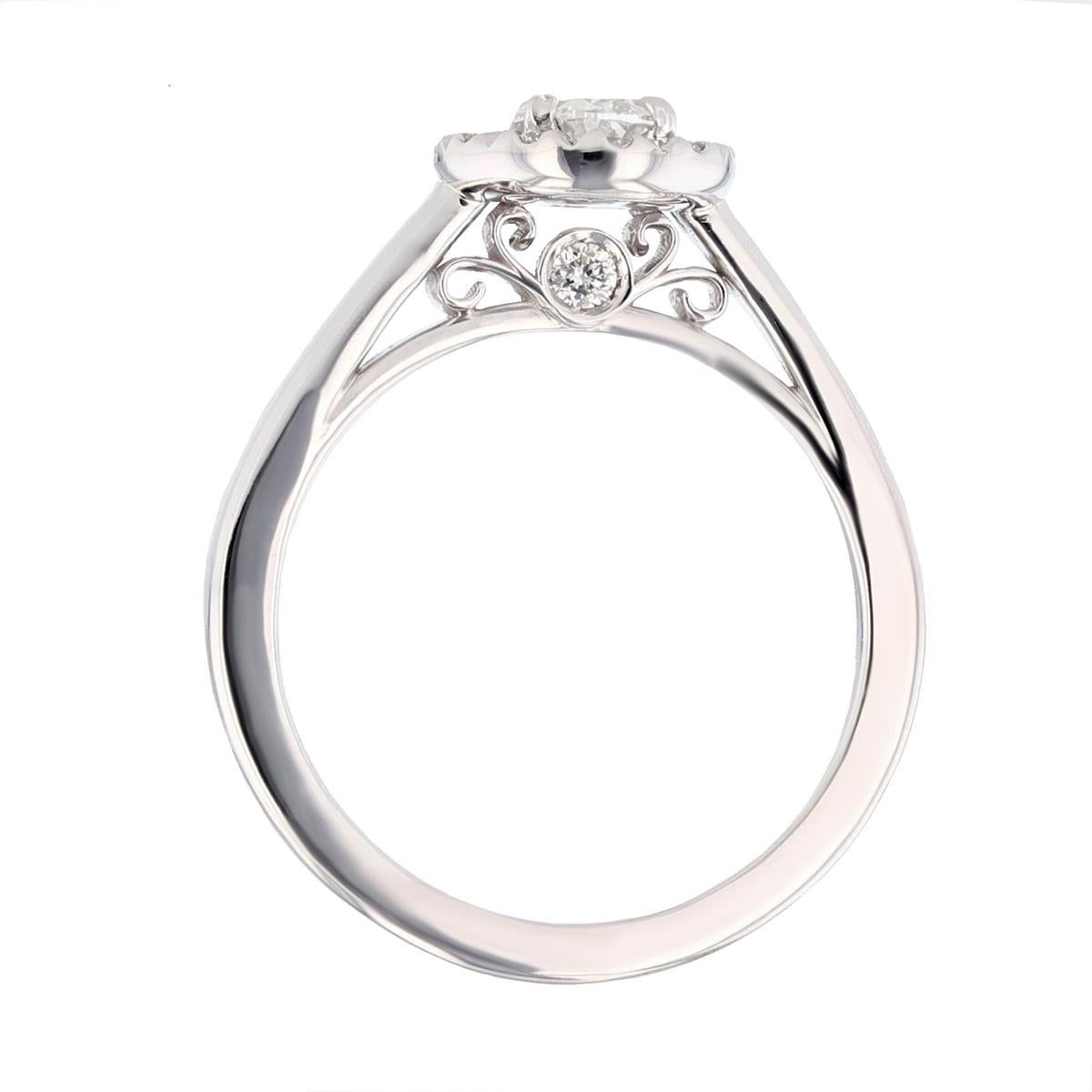 This ring is made with 14 karat white gold and features a prong set  0.48ct  IGI certified oval cut diamond (IGI Certificate number: IGI 9272811), with a color grade (E) and clarity grade (I1) and is surrounded by 14 round cut diamonds weighing