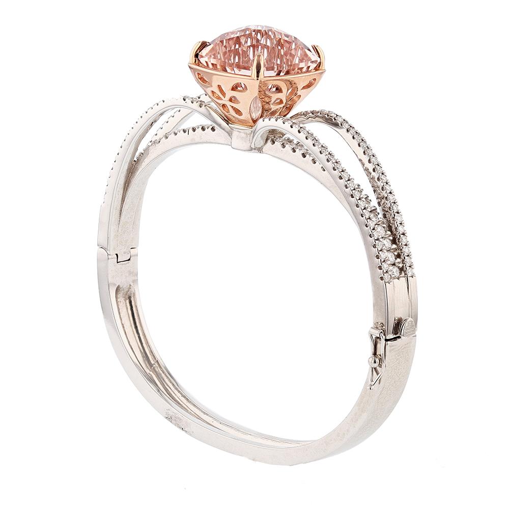 This bangle is made with 14K white and rose gold and features 1 cushion morganite with a unique cut weighing 20.45 ct. The bangle also features 119 round cut diamonds weighing 1.97ct with a color grade (G) and clarity grade (VS2)