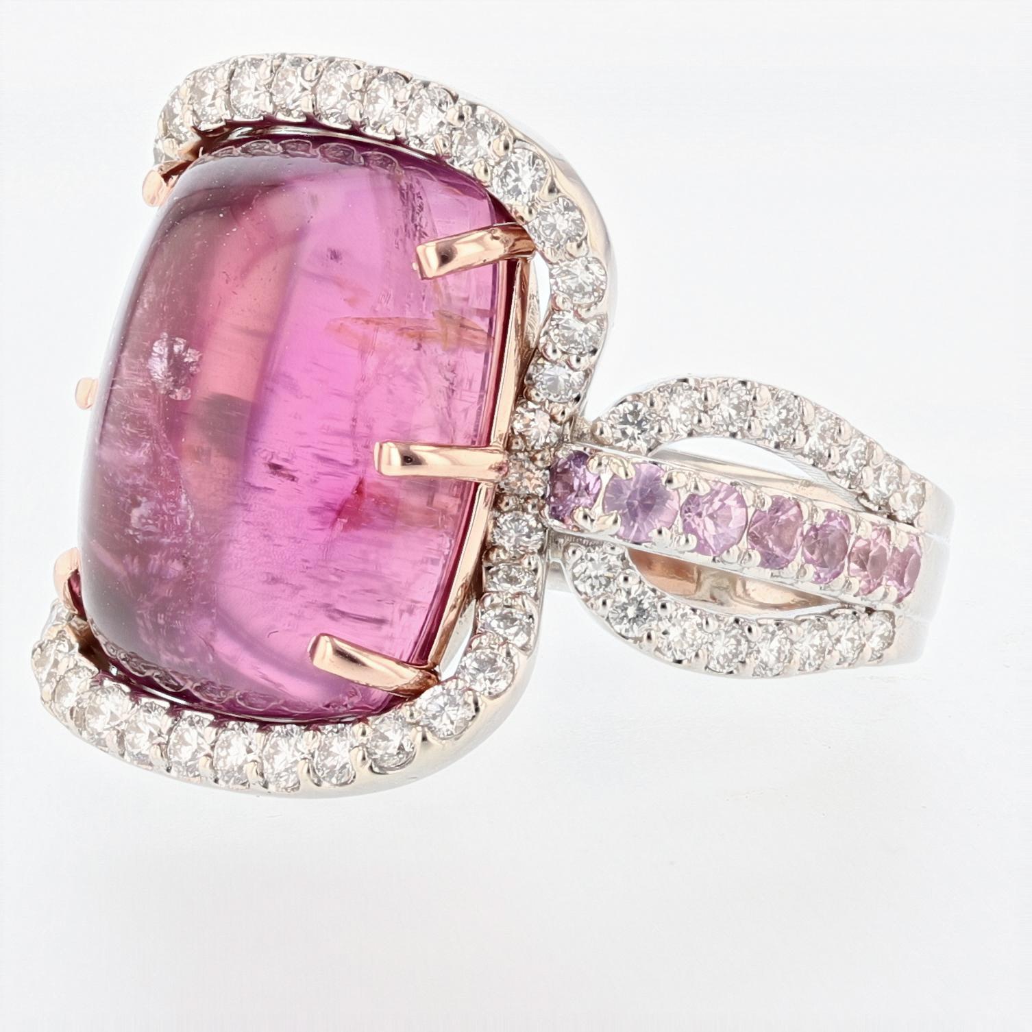 This ring is made in 14K White and Rose gold featuring 1 cabochon Pink Tourmaline weighing 13.90 ct that is prong set. There are 14 round cut pink sapphires weighing 0.71 ct, pave set and 74 round cut pave set diamonds weighing 1.12 ct with a color
