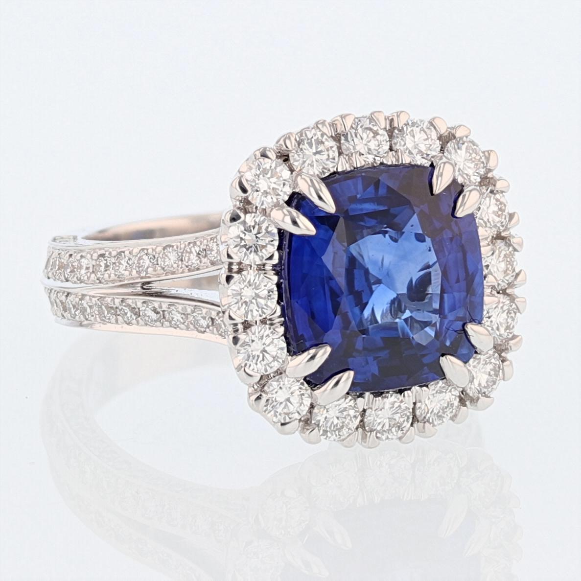 This ring is made in 18k white gold featuring one Cushion Cut Natural Corundum Ceylon Sapphire, CDC certified, with a color grade of Vivid Blue (Cornflower Blue) weighing 5.06 ct. The certificate number is CDC 1601348. The ring features 136 round