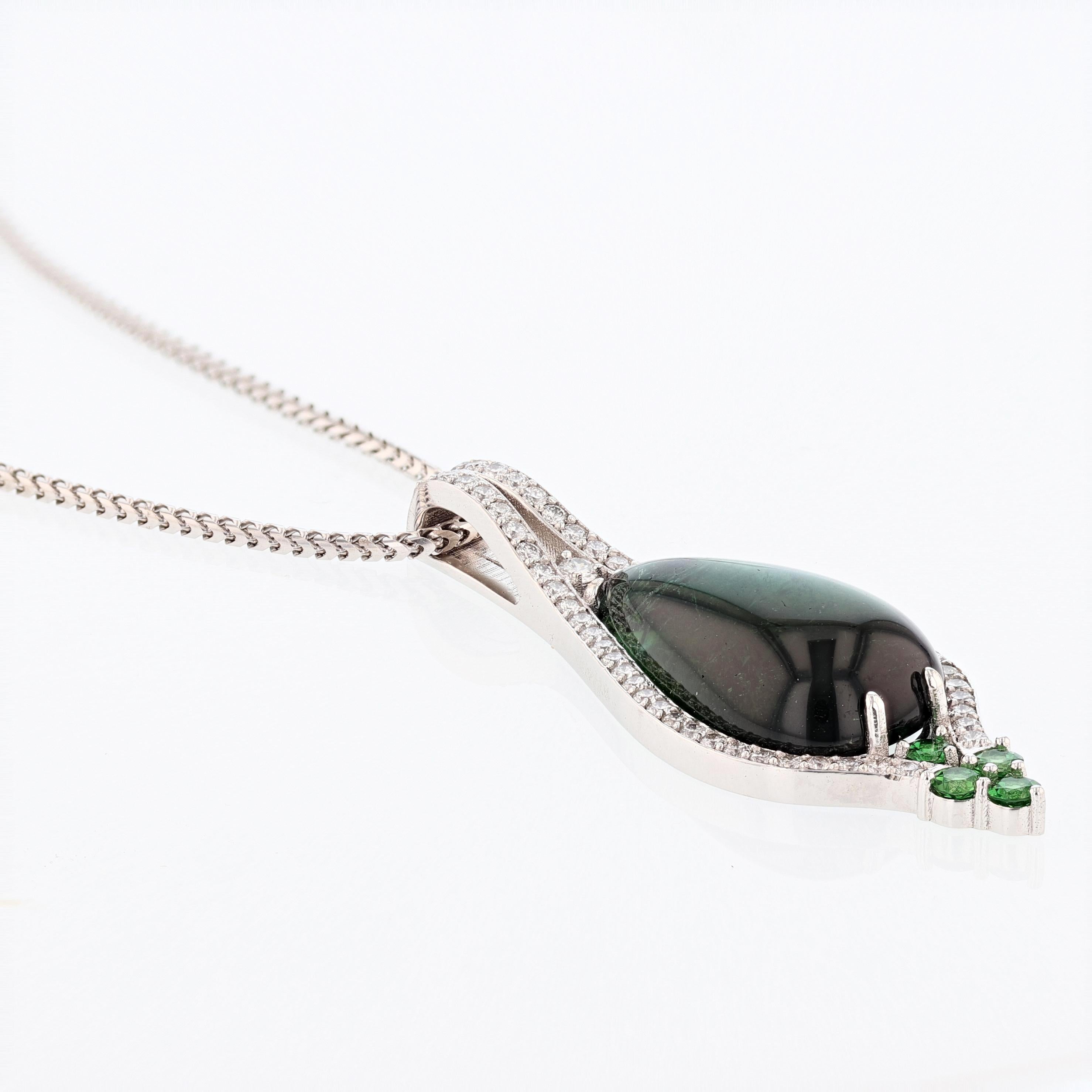 The pendant is set in 18k white gold and features a prong set 20.55ct Pear shape Cabochon Green Tourmaline. The Green Tourmaline is surrounded by 57 round cut brilliant diamonds weighing 1.00ct with a color grade (H) clarity grade (SI1-SI2) and 4