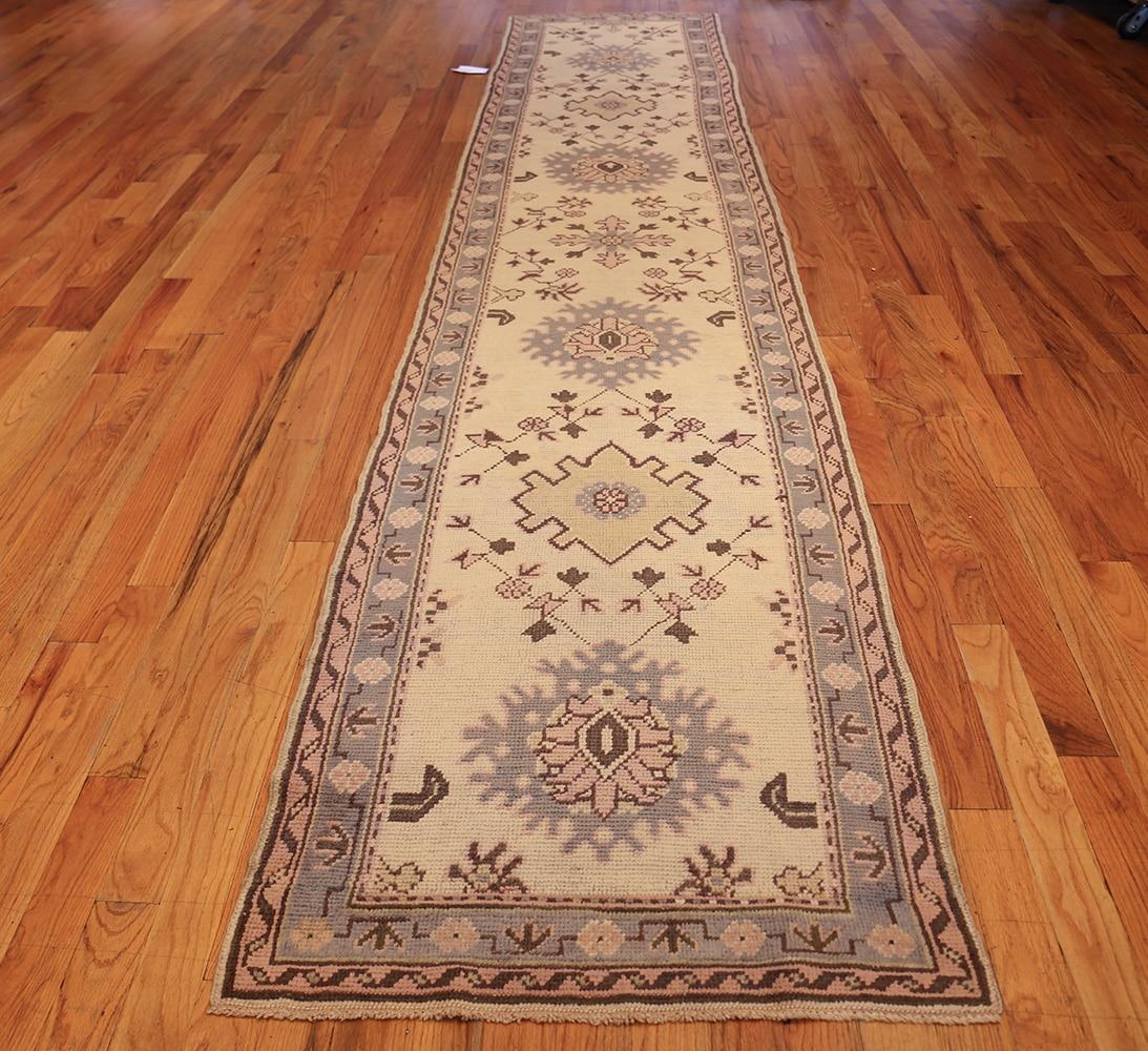 Antique Turkish Oushak Runner rug, country of origin: Turkey, date circa 1900. Size: 3 ft. x 15 ft. (0.91 m x 4.57 m)

With a singular, yet subtle mix of geometric pattern and floral, this runner carpet’s border has a repeating floral medallion