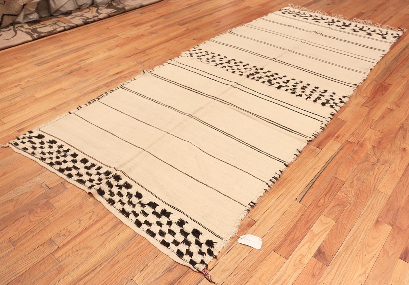 Magnificently soft and tribal ivory and black vintage Moroccan rug, origin: Morocco, circa mid-20th century. Size: 5 ft 7 in x 12 ft 2 in (1.7 m x 3.71 m). This beautiful, simple rug is from mid-20th century Morocco, but it could just as easily have