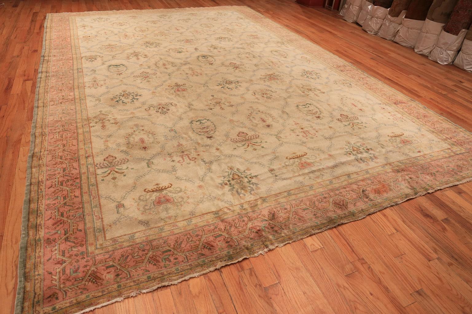 Vintage Sivas carpet, origin: Turkey, circa mid-20th century - Size: 11 ft 9 in x 17 ft 3 in (3.58 m x 5.26 m). 

A rich, grapefruit pink border surrounds the Sivas carpet, its interior containing a pleasantly curling vine that establishes an almost