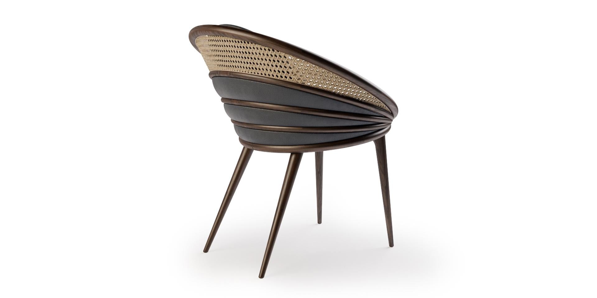 La chaise de salle à manger Ndebele, fabriquée en noyer, nous apporte cette combinaison d'art et de fonction. Ses courbes contrastent avec l'élégance de l'épaisseur et créent une chaise sophistiquée et moderne. La forme ronde garantit le confort et