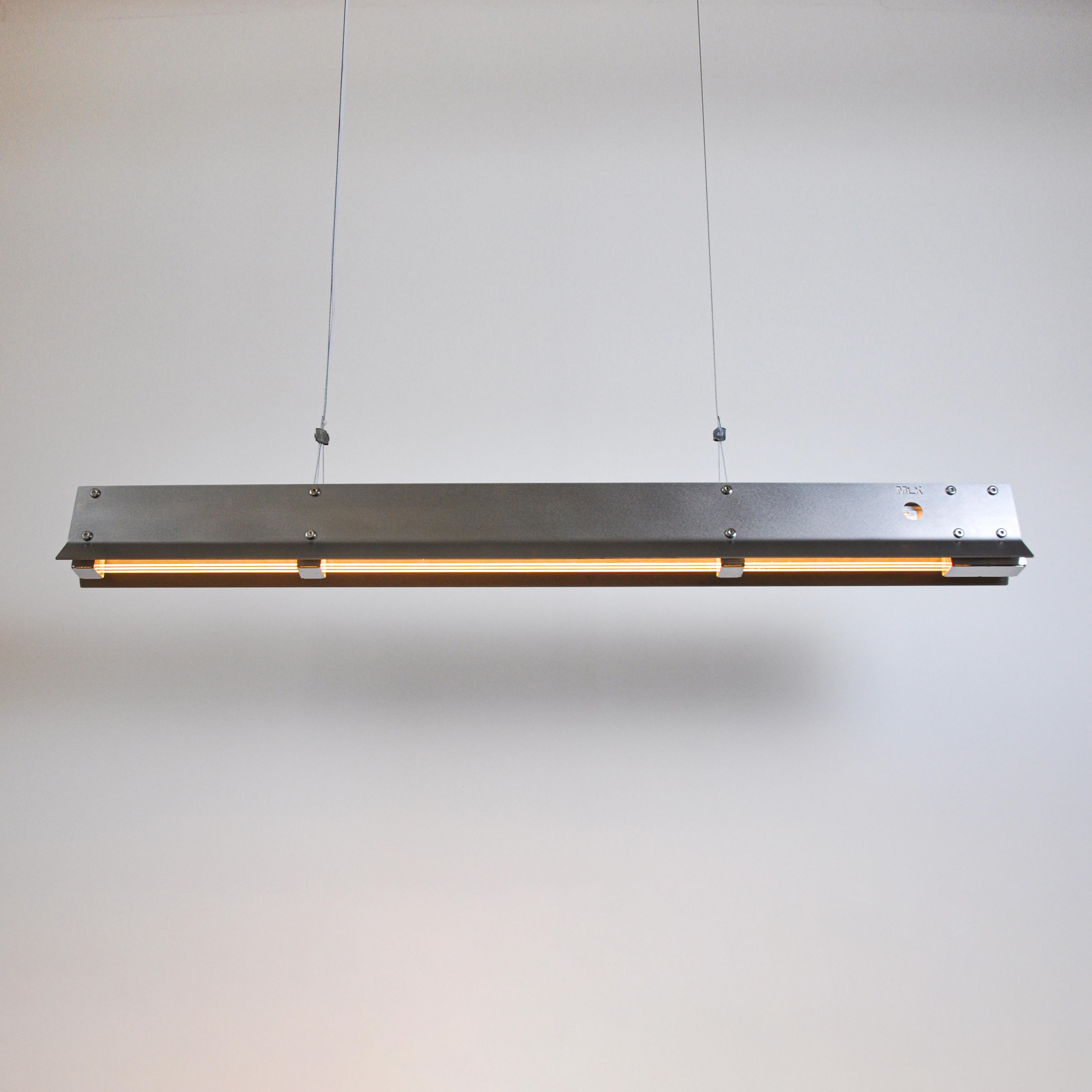 Lampada a sospensione Ne1200 di MLK Furniture
Dimensioni: D. 9 x L. 120 x H. 12 cm.
Materiali: Acciaio inossidabile, acrilico.

Disponibile in versione mat o mat e specchio interno.
Disponibile anche in ottone, rame o acciaio inossidabile.