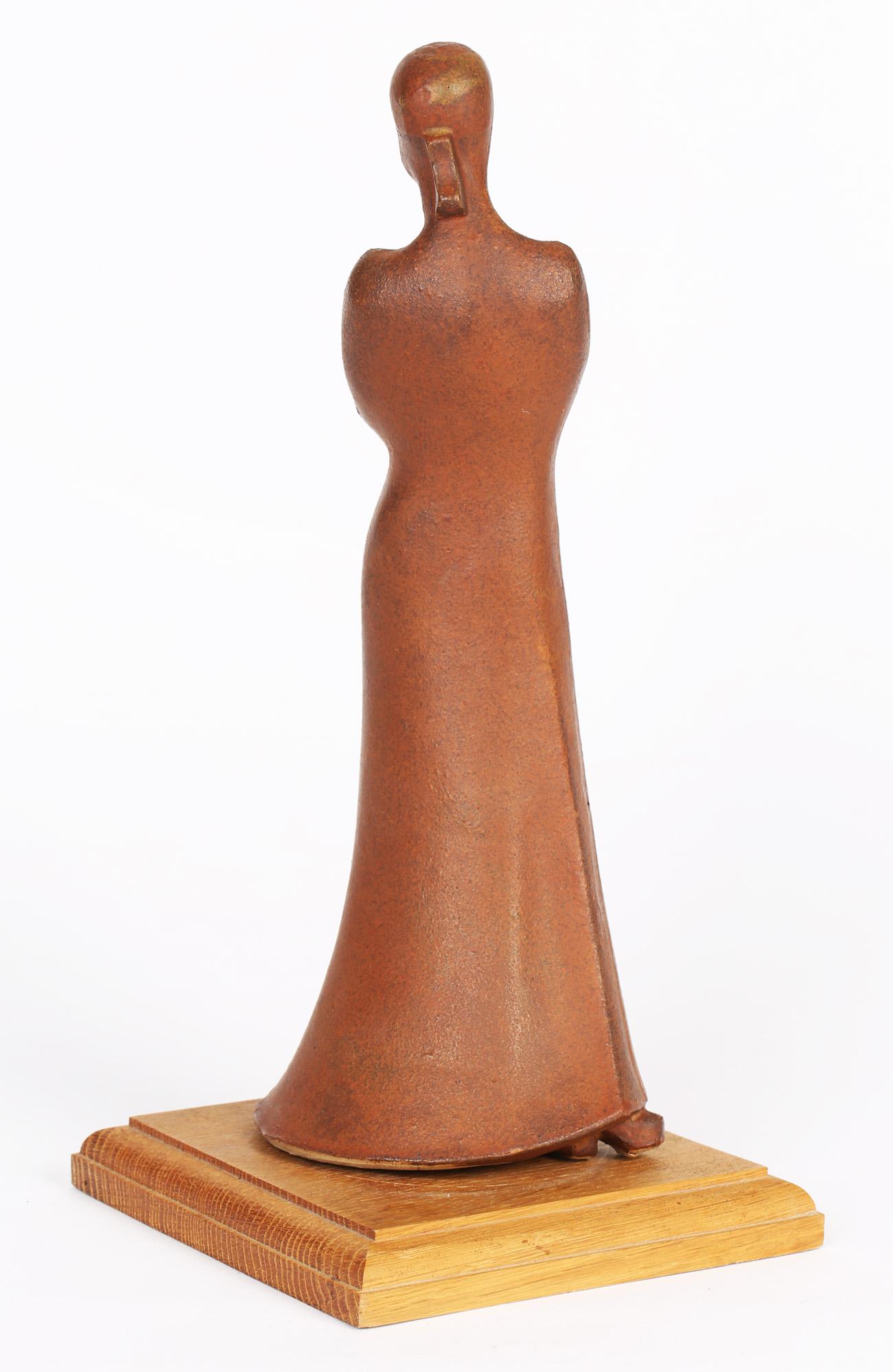 A very stylish terracotta sculptural figure of a lady by renowned sculptor Neal French dating from the latter 20th Century. The figure stands mounted on a wooden base and is simply modeled and in slight abstract wearing a long flowing dress with a