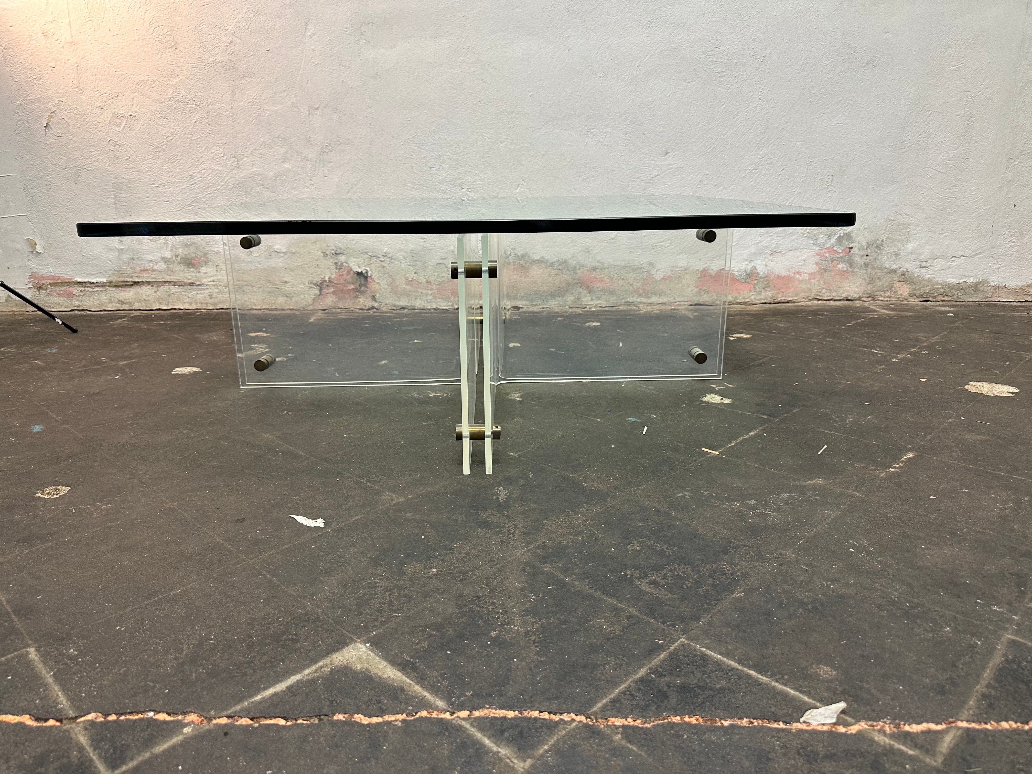 This is a gorgeous Lucite and glass with brass rivets coffee table by Neal Small. The glass is excellent and 3/4