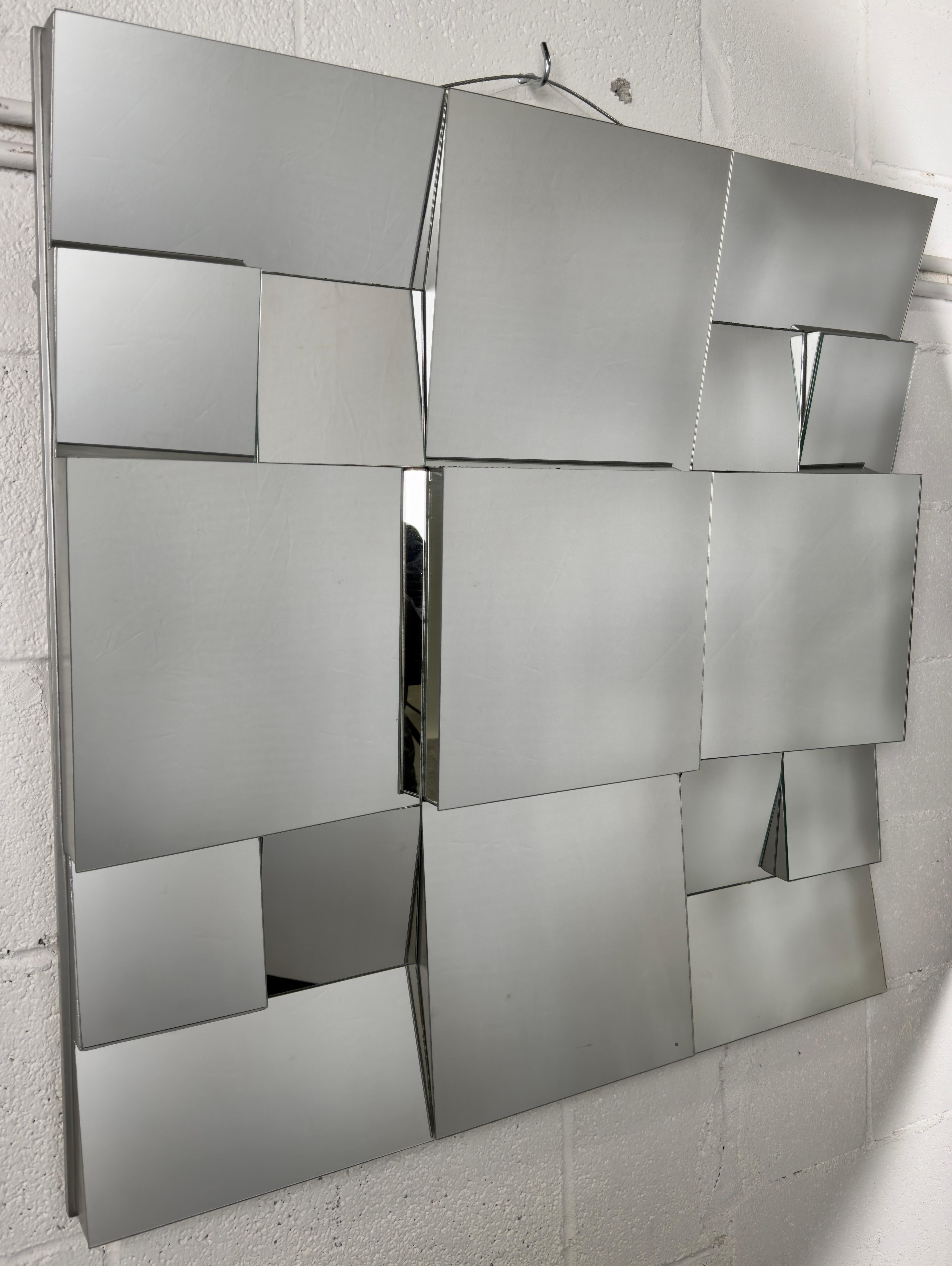 
Ein ikonischer Neal Small (Amerika, 1937)  Schräggestellter Spiegel im kubistischen Design, 1975 von dem visionären amerikanischen Designer entworfen. Jede Facette des Spiegels spiegelt die Meisterschaft von Small wider, während die emaillierte