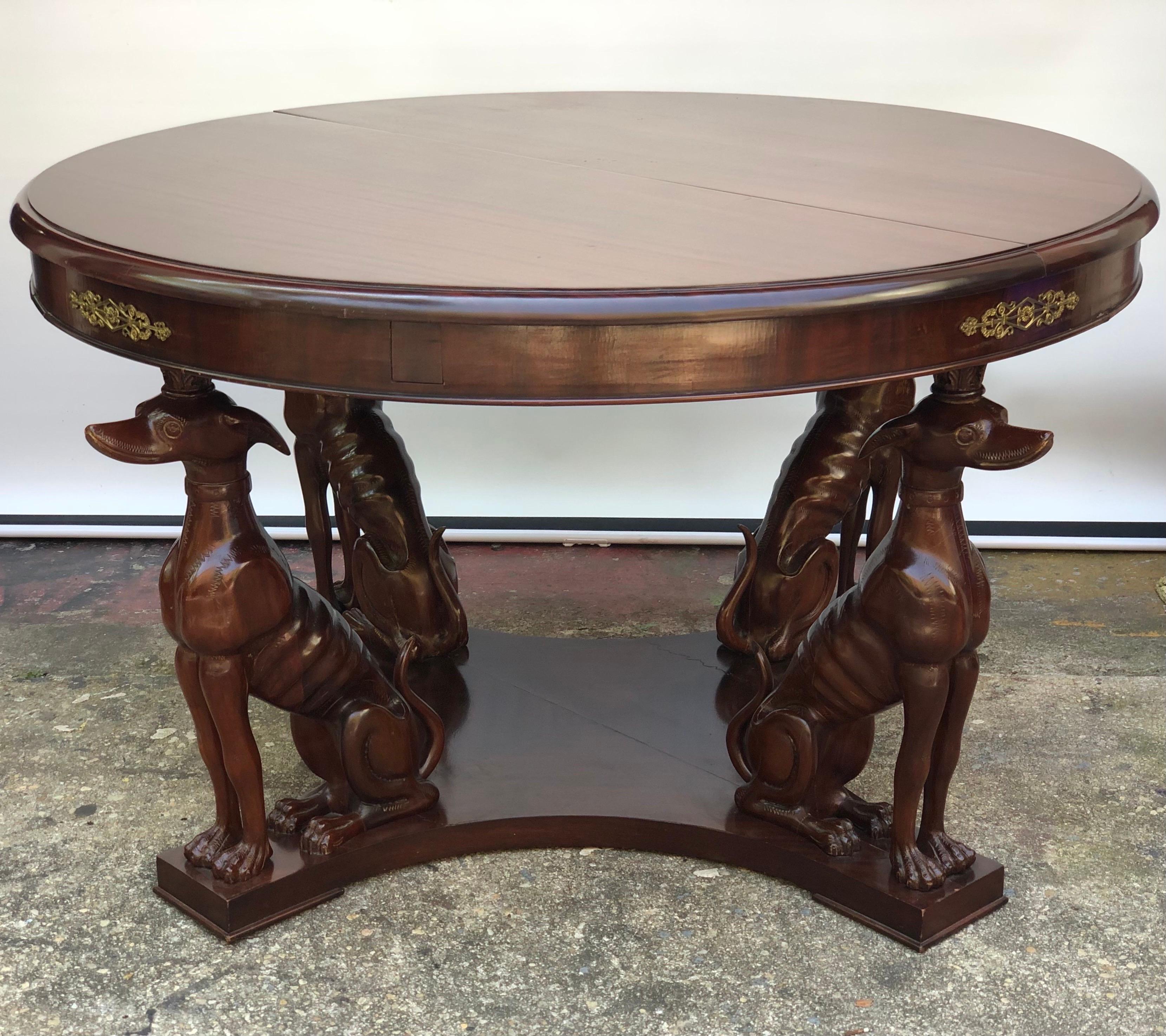 Regal Neapolitan style Art Deco whippet center table with bronze mounts made in the 1920s - 1930s. The round mahogany top is supported by four carved mahogany whimsical Whippets supporting a mahogany frieze with bronze mounts. The Deco Whippet Round