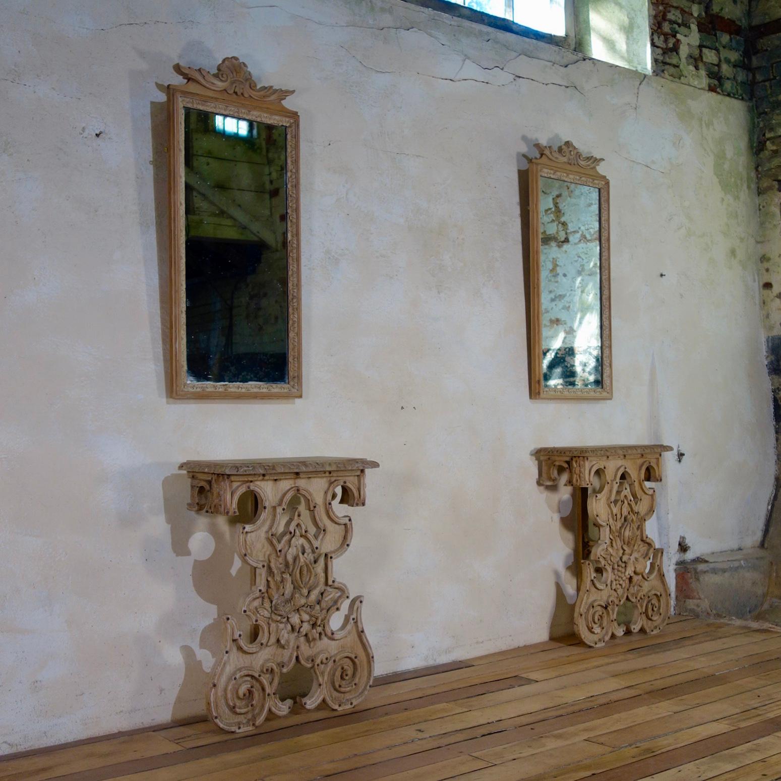 A near pair of continental carved bleached oak pier mirrors with matching console tables - Reconstructed from 18th century elements in the 19th century. 

Demonstrating extremely well-executed carvings throughout with metal studs to the base.