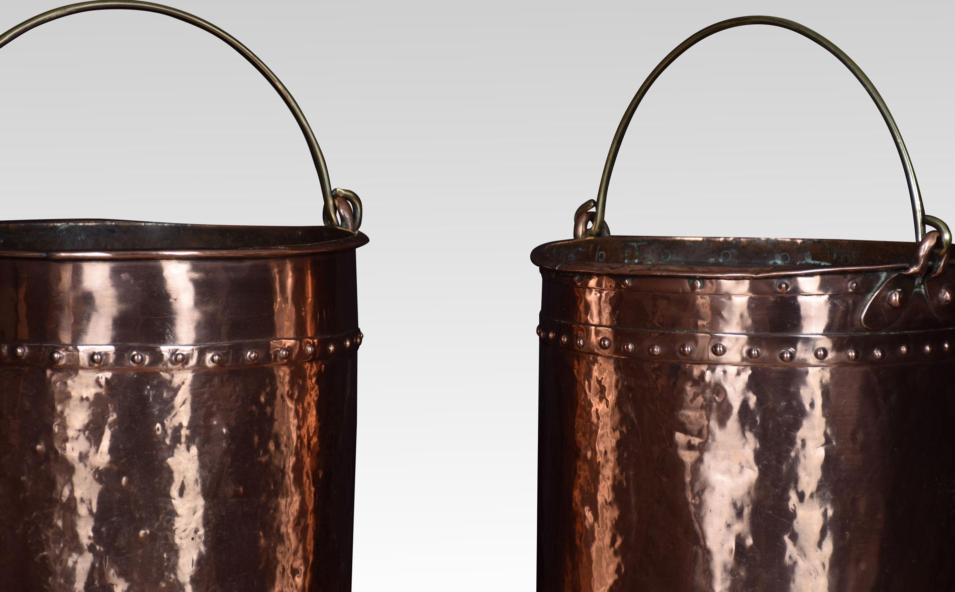 Near pair of 19th century copper coal buckets, each with rivet detail and applied with brass swing handles.
Dimensions
Large bucket
Height 12 inches
Width 13.5 inches
Depth 13.5 inches 

Smaller bucket
Height 11.5 inches
Width 13