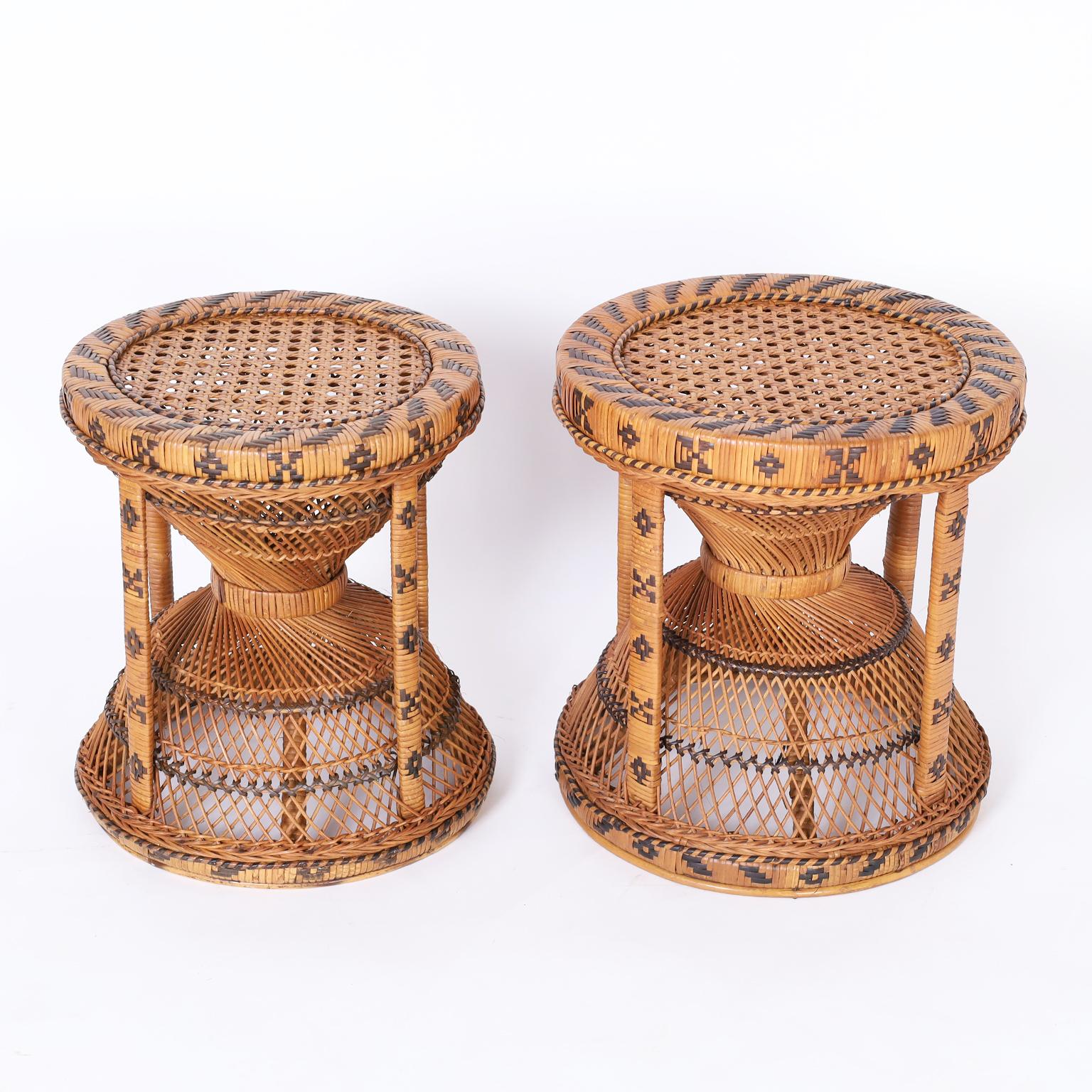 Anglo Indian near pair of ottomans crafted with wicker and reed in a classic hourglass form with caned seats and painted geometric designs.
 