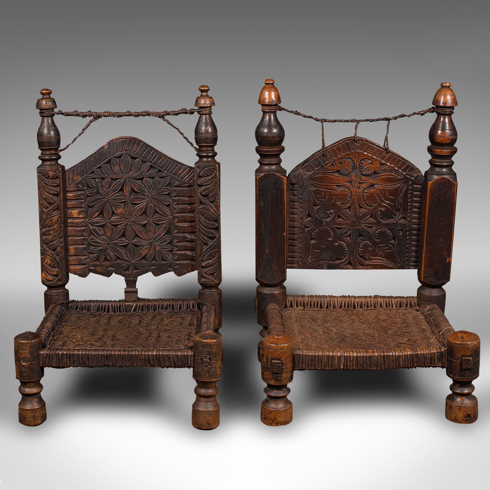 This is a near pair of antique carved temple chairs. A Burmese, mahogany and woven leather low chair, dating to the early Victorian period, circa 1850.

Utterly fascinating carved chairs, with distinctive low form and appealing detail
Displaying
