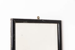 Juego de dos espejos de pared antiguos de madera ebonizada con aspecto desgastado y manchas de óxido. Hacia 1920