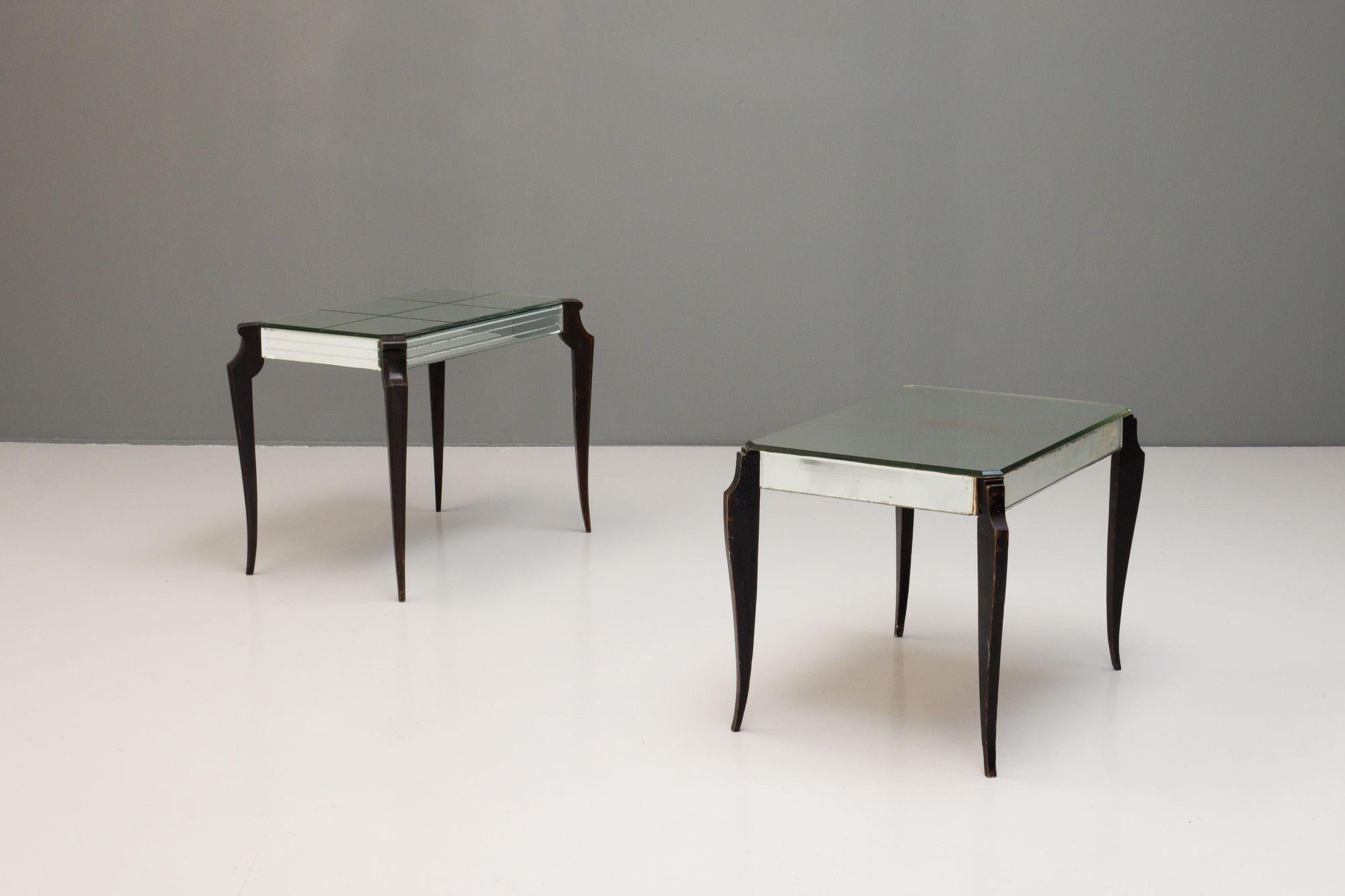 A near pair of art deco style mirrored side tables with ebonised shaped legs.
The glass shows signs of wear in line with age and use. As shown in images.
H: 51cm W: 66cm D: 44cm
H: 47cm W: 67cm D: 47cm