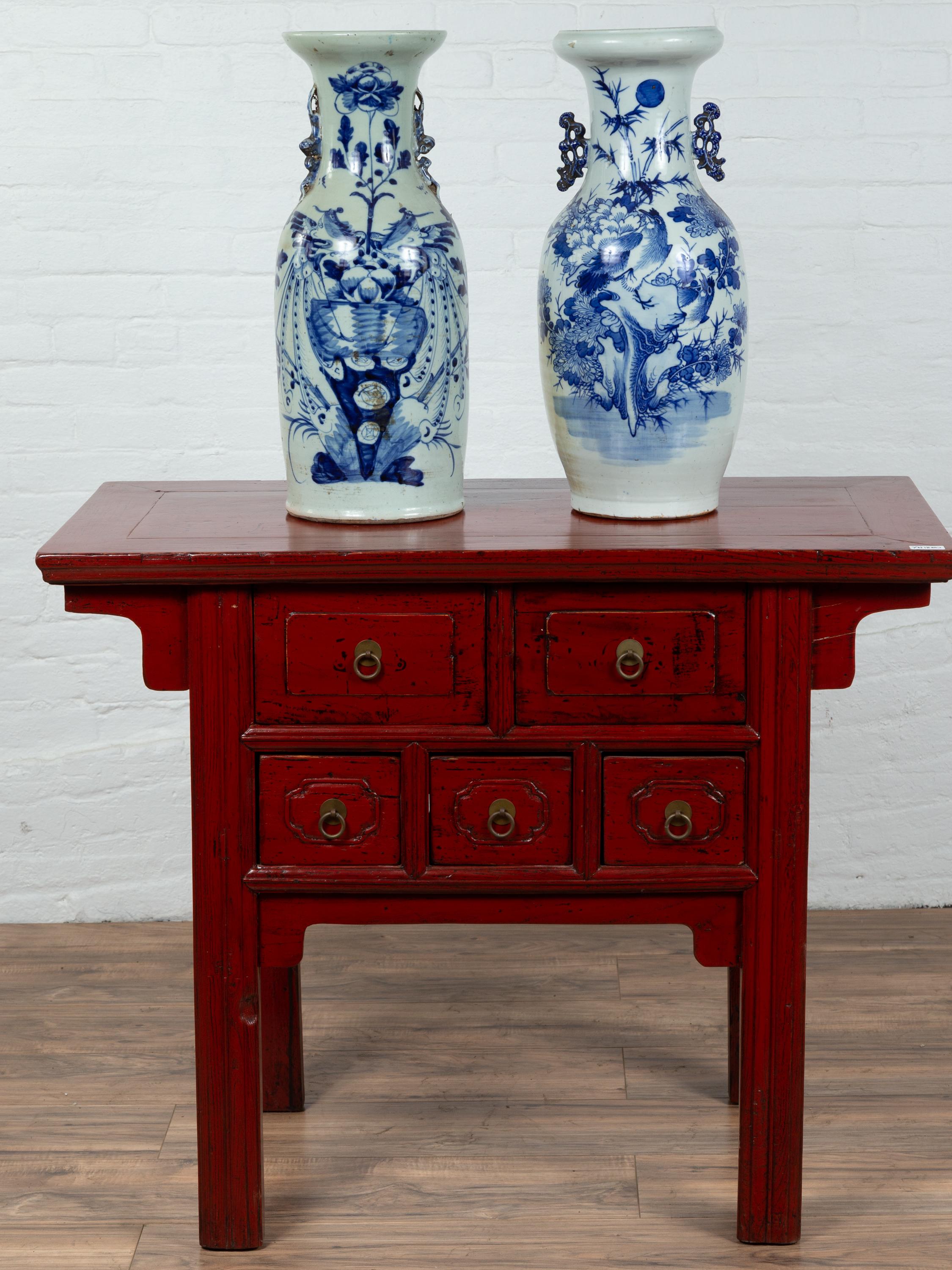 A near pair of antique Chinese porcelain altar vases with hand painted blue motifs. Capturing our attention with their elegant lines and hand painted décor, this near pair of altar vases will make for a great decorative accentuation in any home.