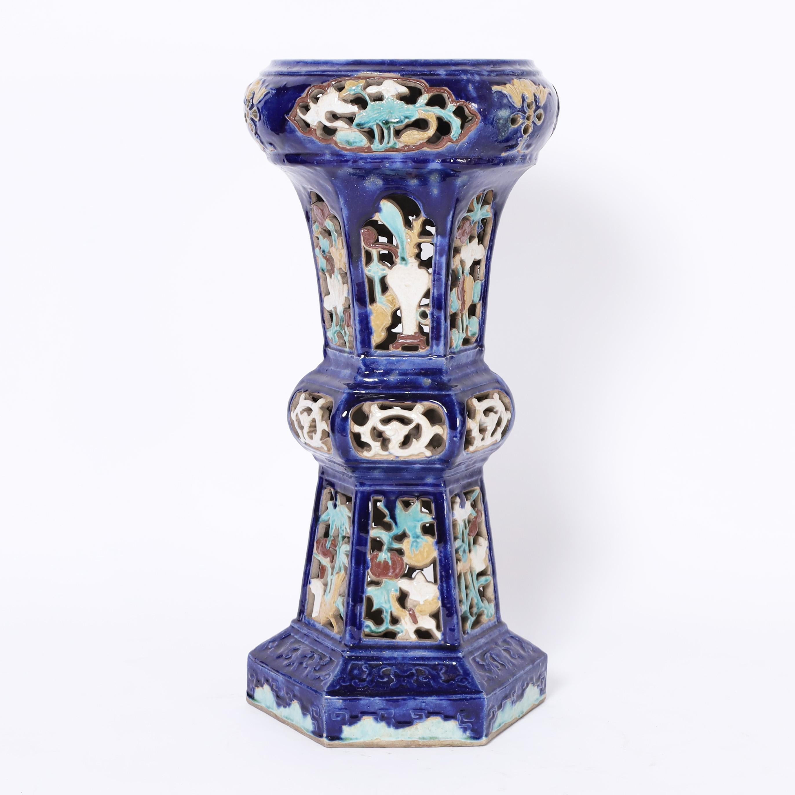 Striking pair of vintage Chinese pedestals handcrafted in terracotta in classic form with open fretwork, decorated in soft floral colors on an alluring cobalt blue background.

From left to right:

H: 29.5 DM: 14
H: 31.5 DM: 14