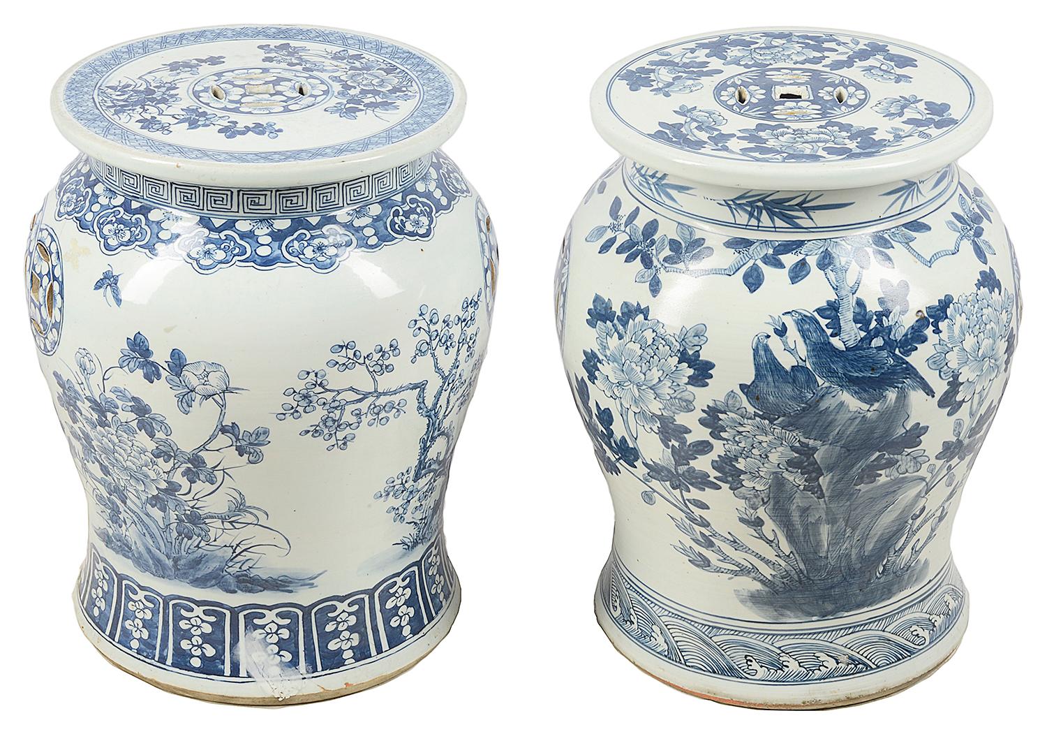 A good quality near pair of early 20th century Chinese blue and white garden seats, each with a bulbous form, hand painted flowers, foliage and birds.