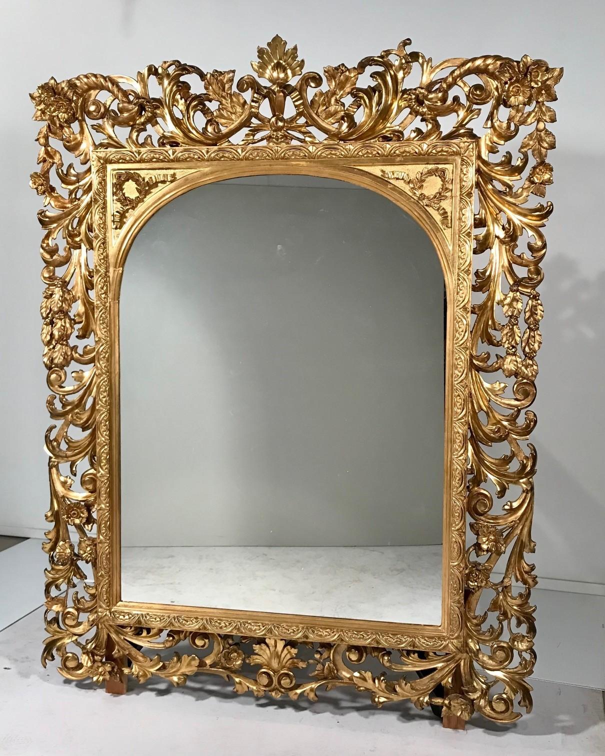 These Florentine mirrors are well-carved and gilt with scrolling acanthus and foliate motifs which create a lively background for the arched mirror plates. They are substantially, though not entirely, identical. A point of difference is the motifs