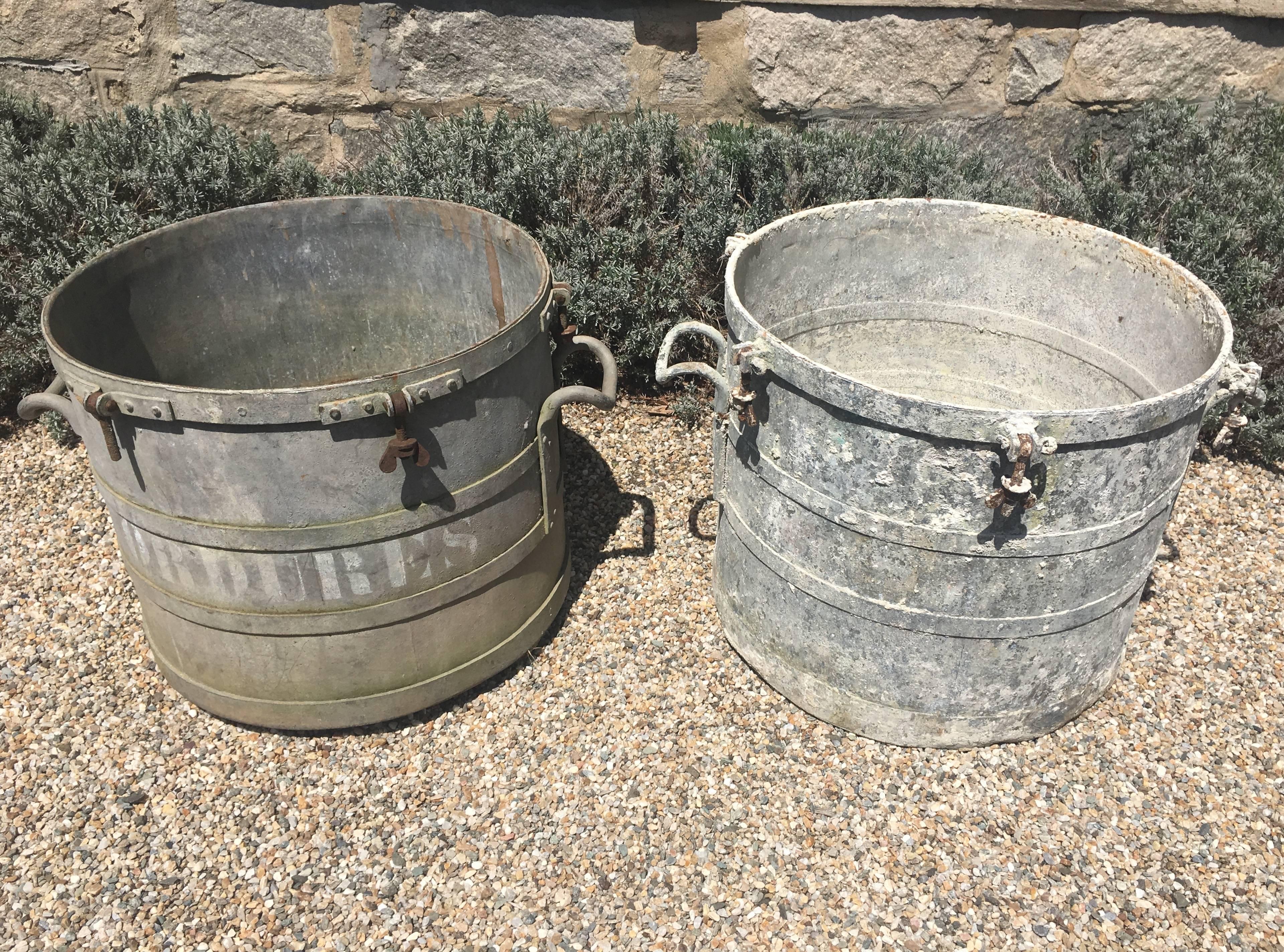 These large round French galvanized zinc planters were originally used for some Industrial function, but their beautifully weathered surface and great size makes them perfect candidates for planters. Large enough to hold topiary or a huge display of