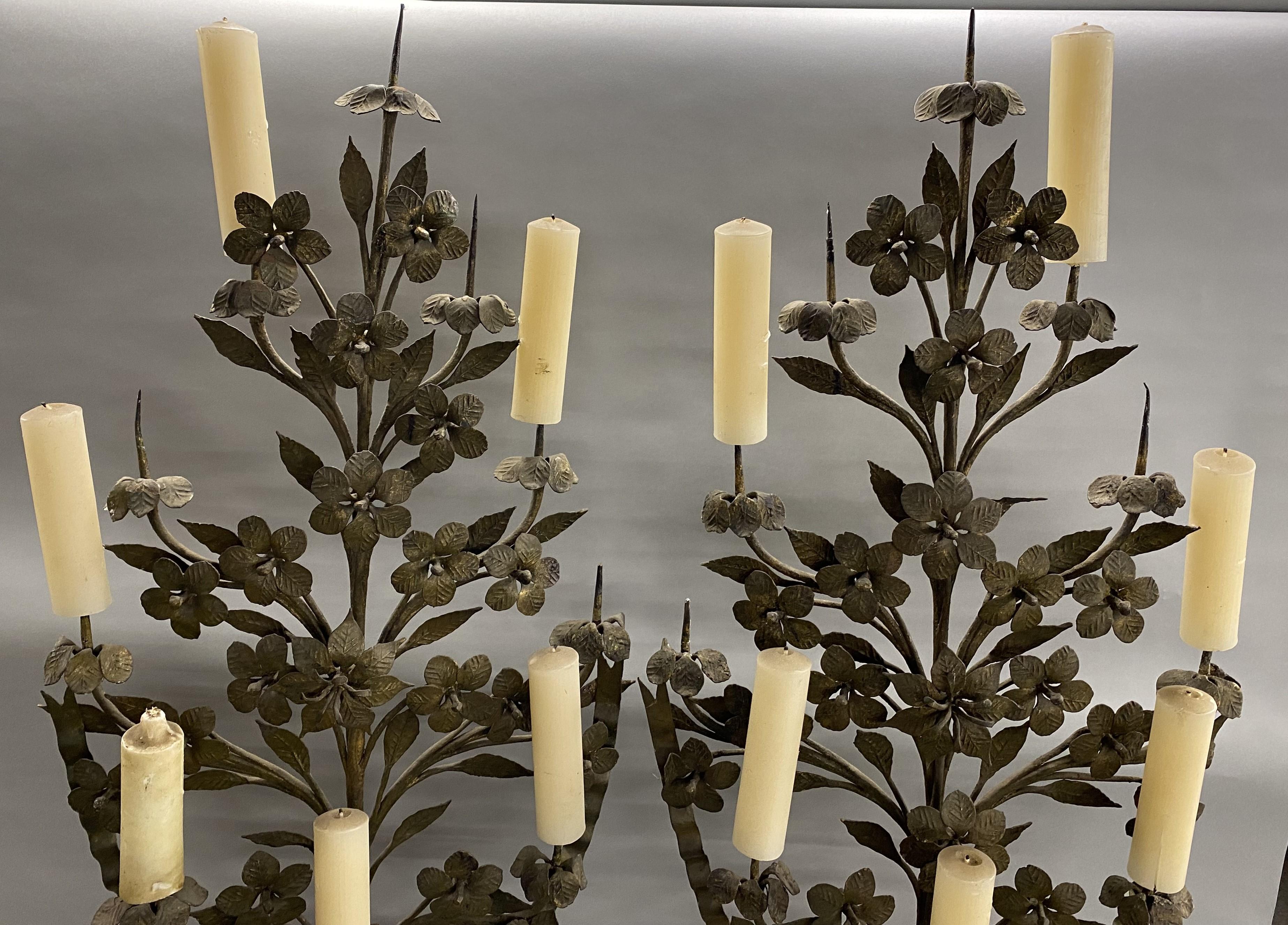 Splendida coppia di candelabri a 9 luci in legno policromo e metallo a forma di fiore e urna su basi quadrate leggermente diverse, con la parte superiore floreale in ferro battuto e la parte dell'urna in legno intagliato, con manici decorati da