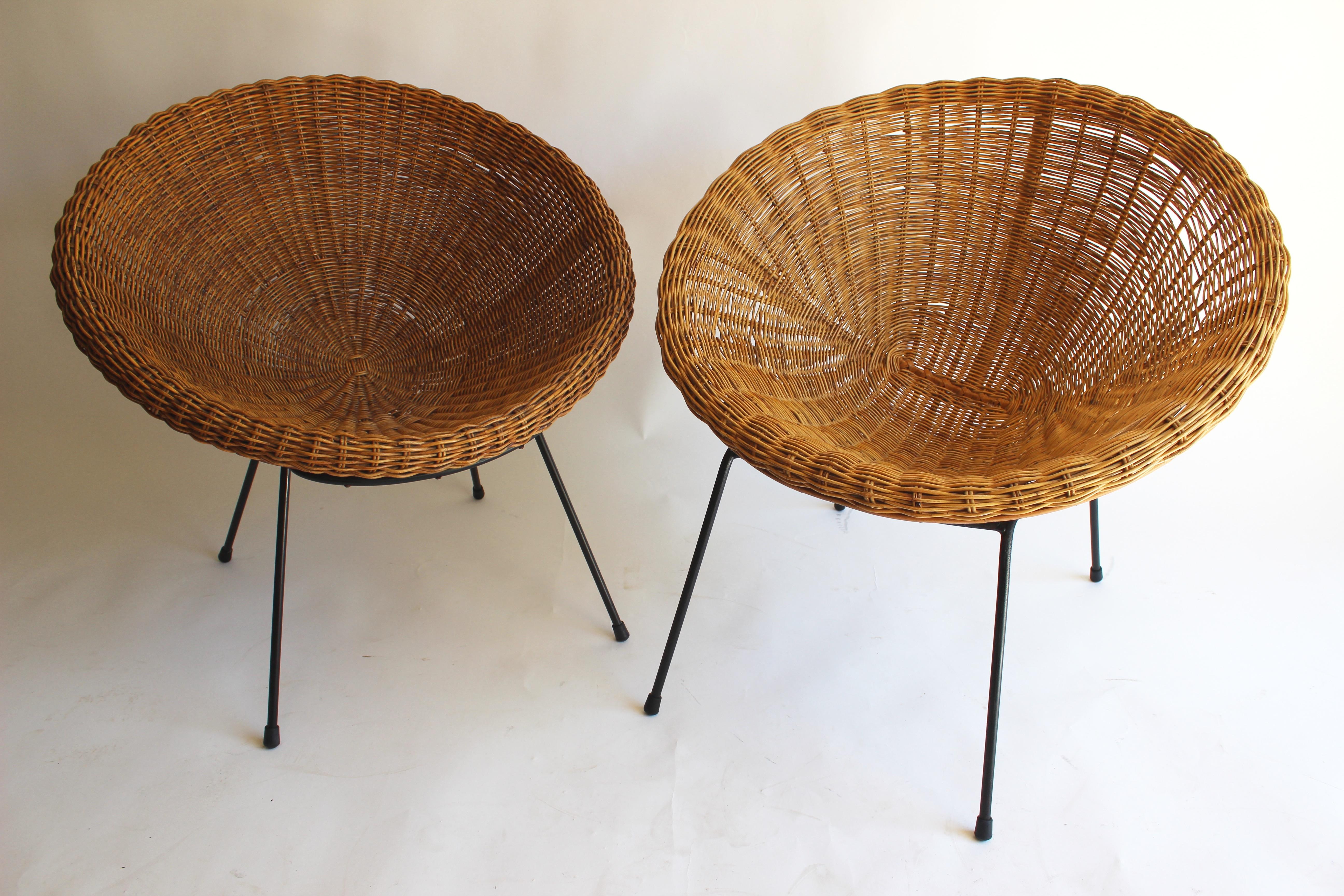 Near pair of rattan and iron lounge chairs in the style of Franco Albini.

They slightly differ in size:
Measures: Smaller: 28