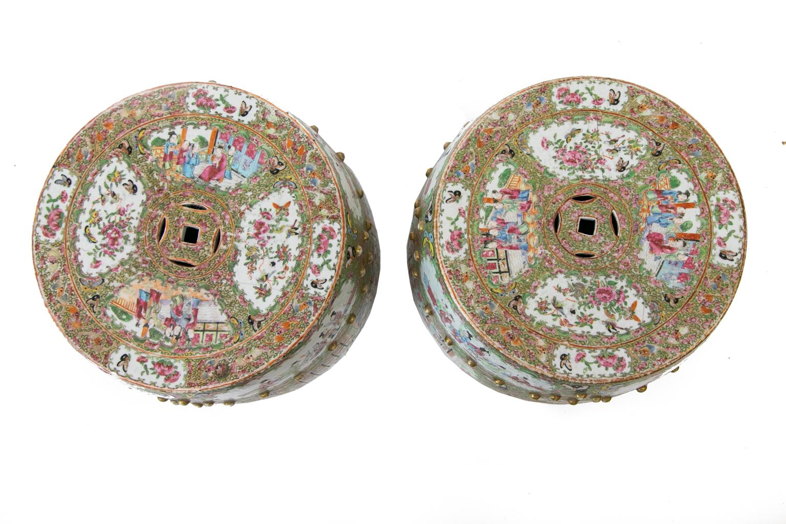 Near pair of Rose Mandarin garden seats, the sides having multiple cartouches with mandarin court scenes with double reticulated medallions bordered by gilt stud work.
 