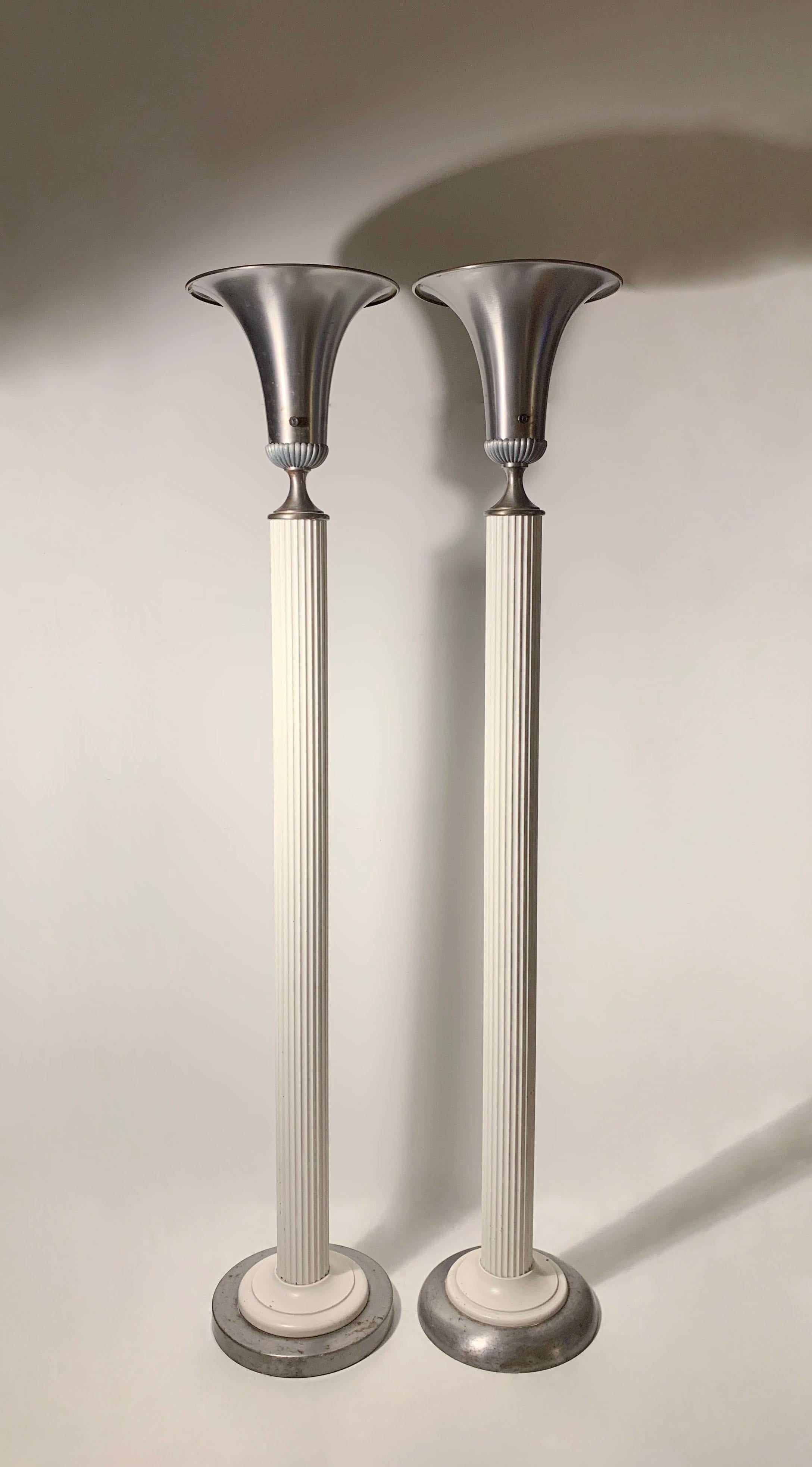 Near pair of vintage Hollywood Regency  deco metal torcheres in the manner of Grosfeld House, Walter Von Nessen. Uncertain to designer/maker.

Base plates are slightly different. One stands a little more than 1/4