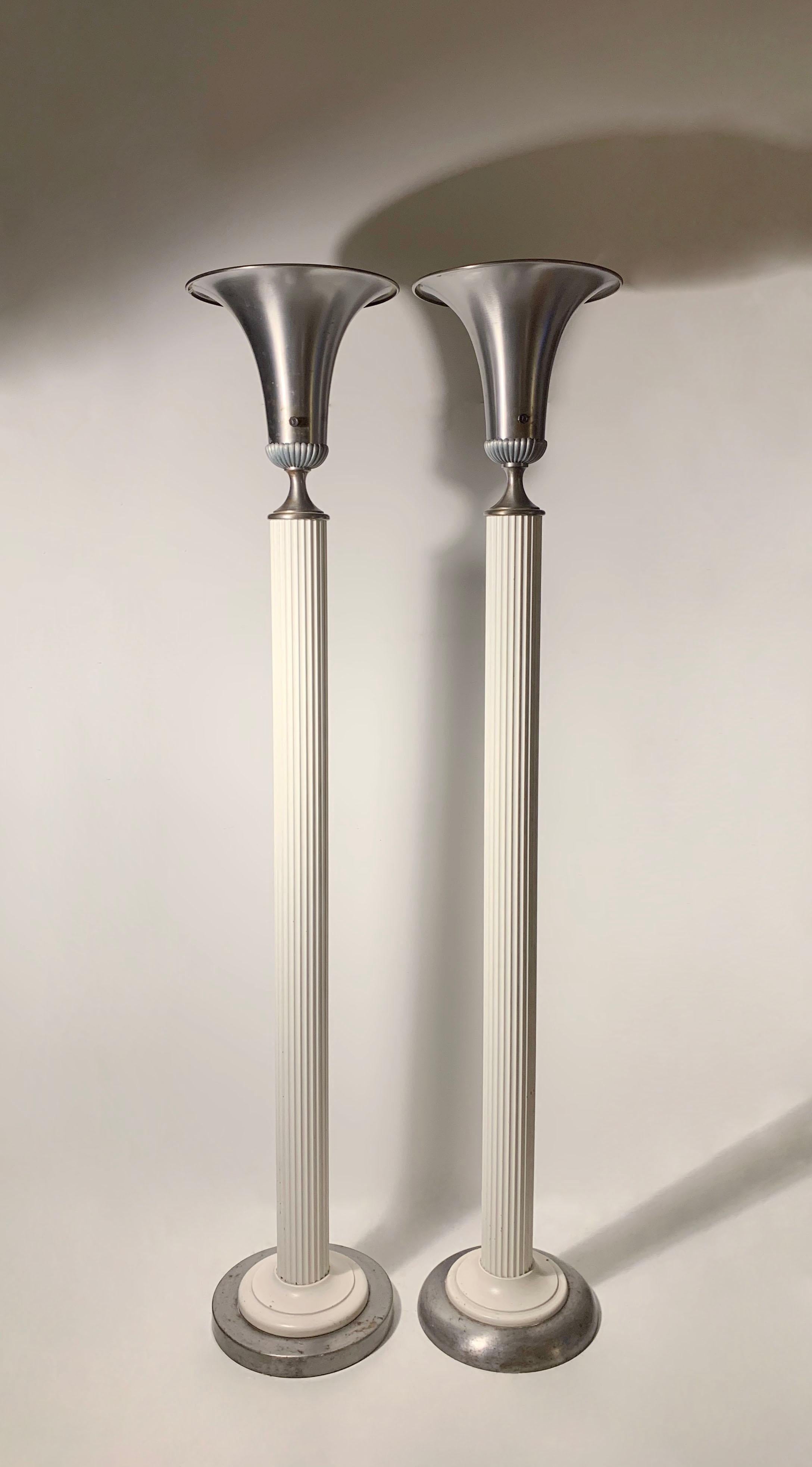 Près d'une paire d'objets vintage Hollywood Regency  torches en métal déco à la manière de la Maison Grosfeld, Walter Von Nessen. Incertain pour le concepteur/le fabricant.

Les plaques de base sont légèrement différentes. L'un d'eux est un peu plus