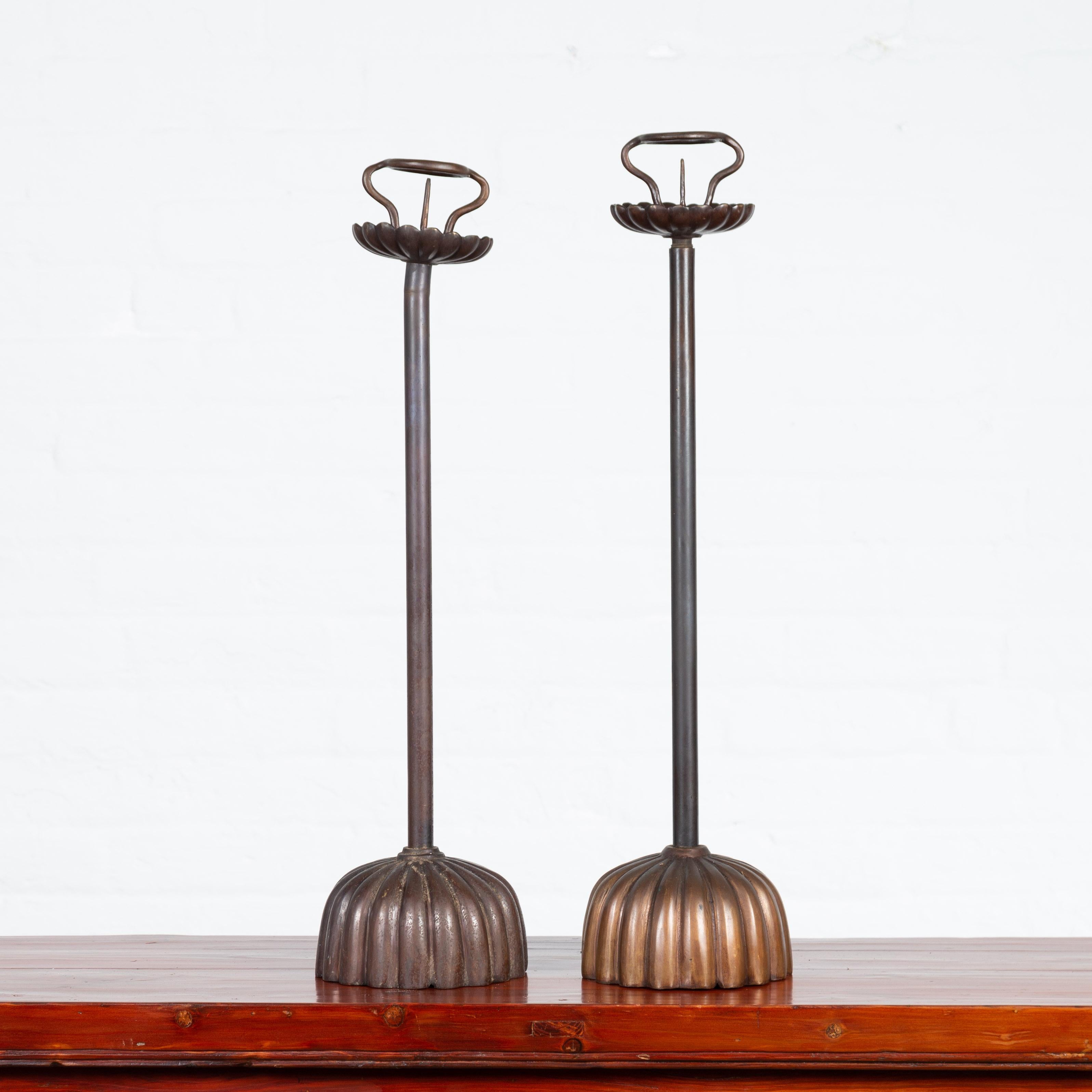 Une paire de chandeliers de style japonais en bronze coulé à la cire perdue avec des motifs de godrons. Nous avons actuellement deux paires disponibles, vendues 750 $ chacune. Créée selon la technique traditionnelle de la cire perdue, cette paire de
