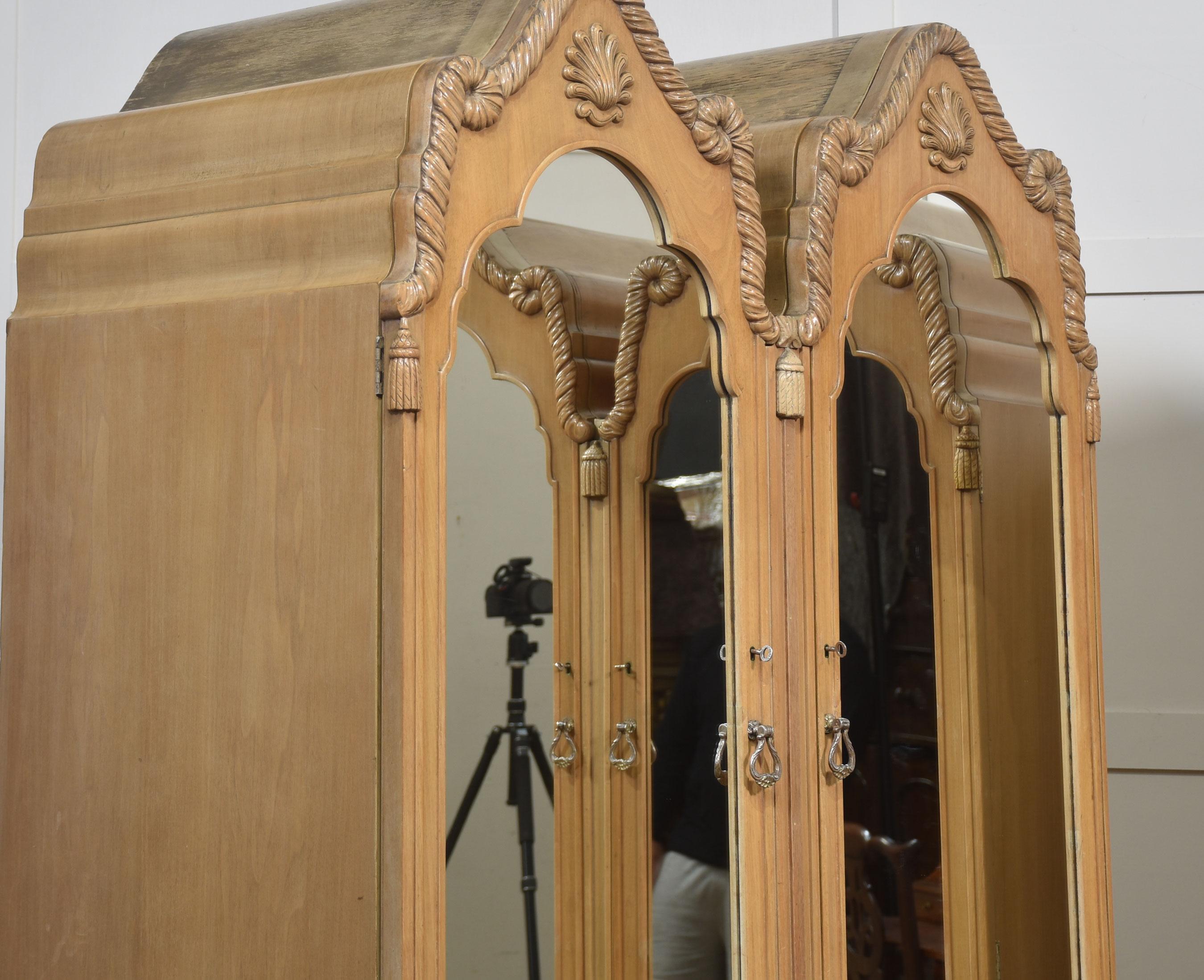 This stunning pair of French-style wardrobes brings timeless elegance and functionality to any interior. Crafted from quality walnut with a beautifully light natural finish, each wardrobe features twin mirrored doors framed with exquisite carved