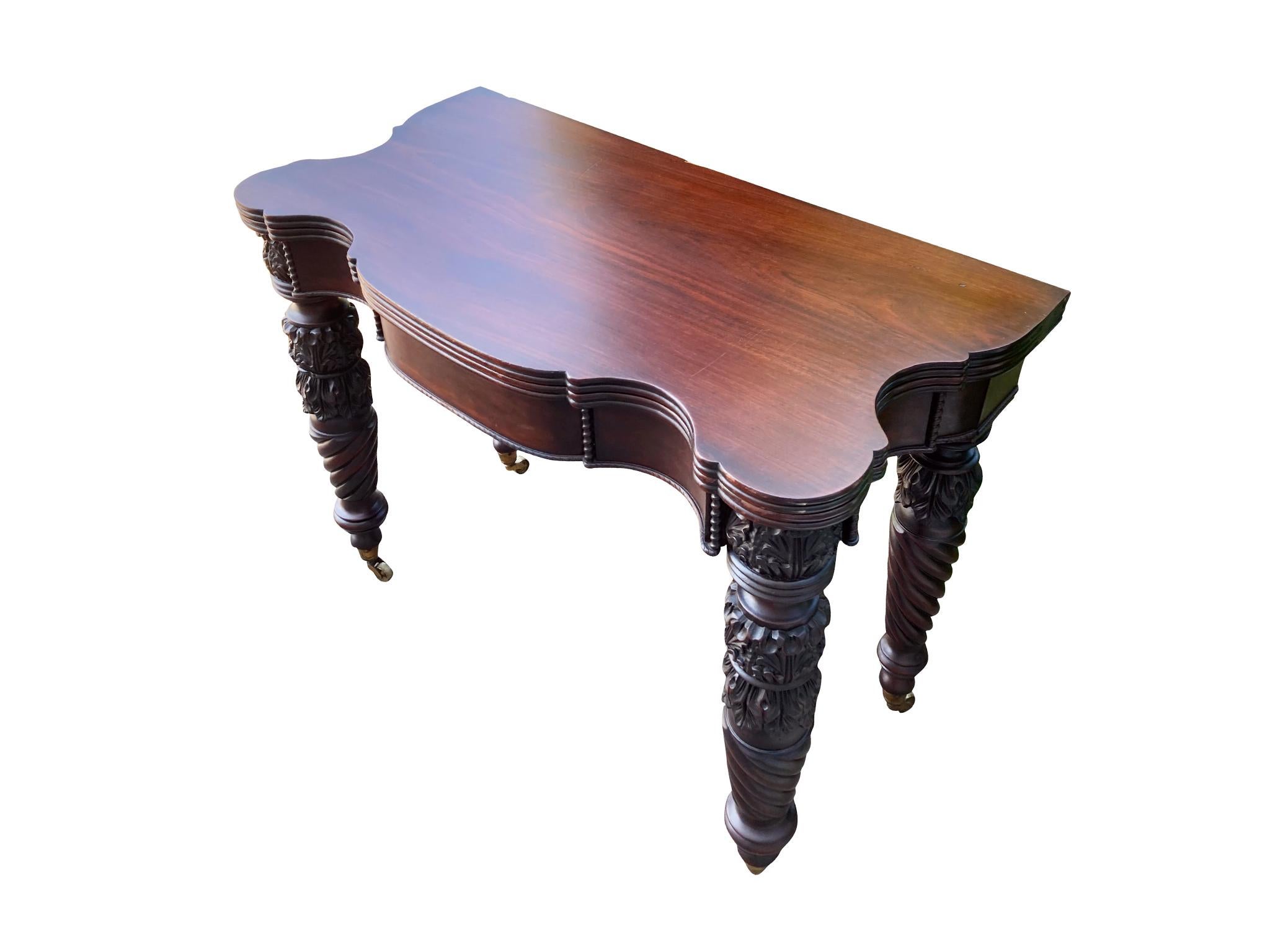 A set of two Federal mahogany folding card tables. Handcrafted circa 1825. They are a near-identical pair with the legs varying slightly in design. These tables are remarkable for their elegant features: the rounded molding of the tops, the