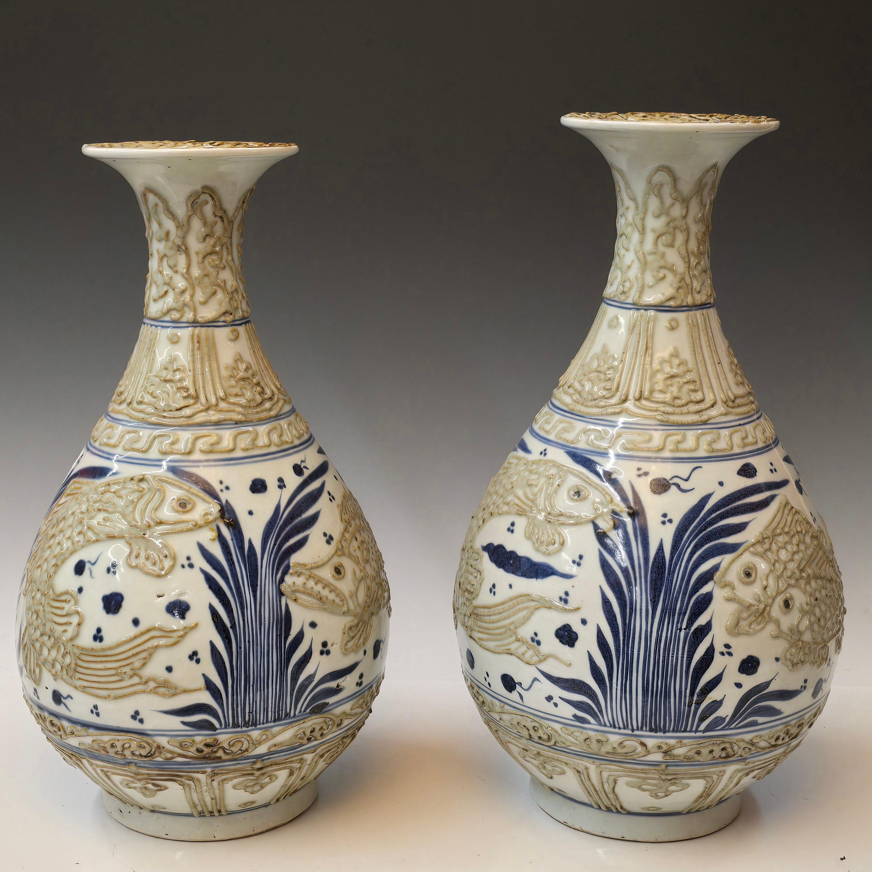 Whiting, vasi blu e bianchi a forma di Yuhuchun  con disegni di pesci in rilievo applicati che variano man mano che si gira intorno al vaso.   Sono stati entrambi realizzati a mano e uno è leggermente più piccolo dell'altro, ma questo fa parte della