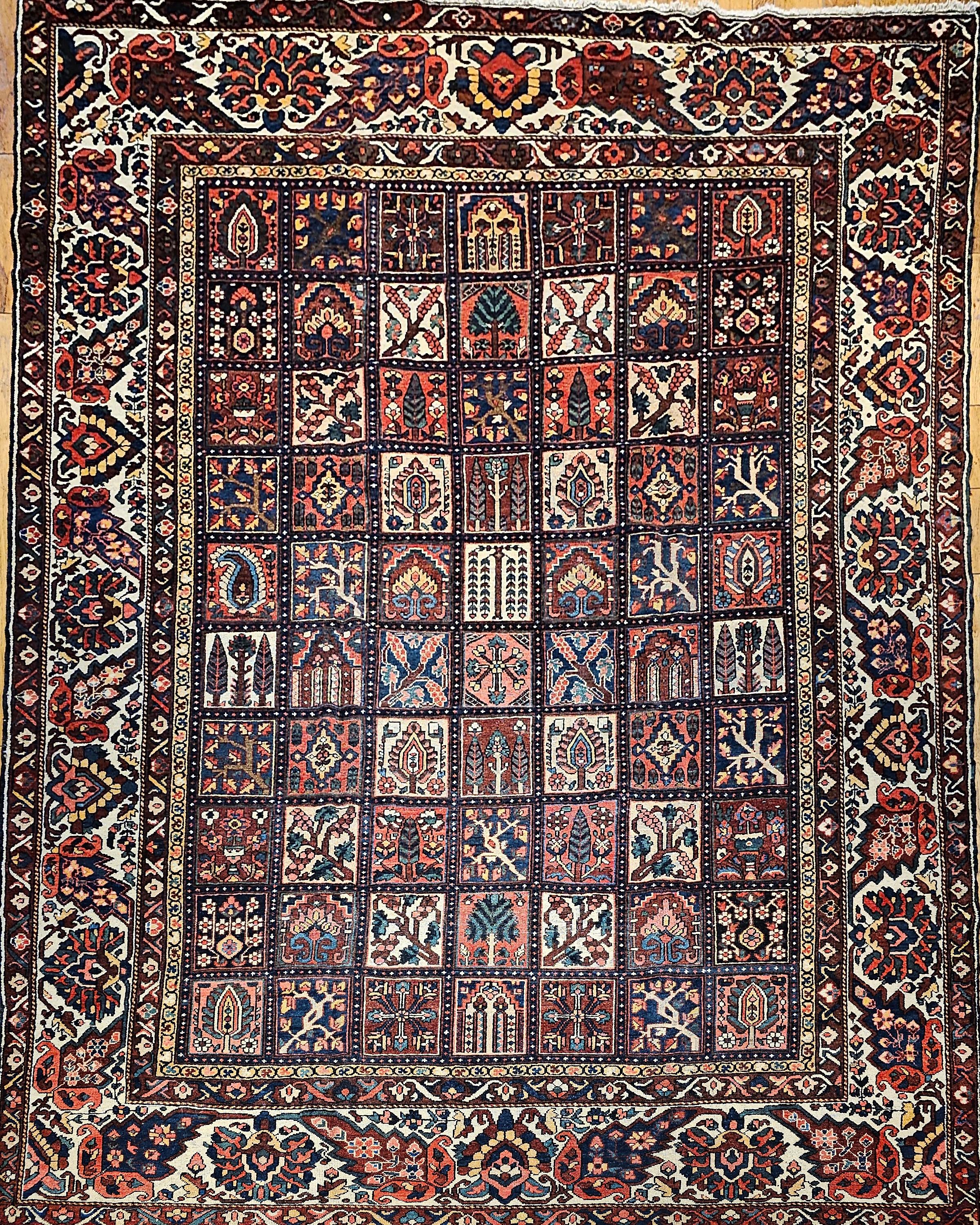 A beautiful “near square” vintage Persian Bakhtiari oversize  rug in garden panel design from the 2nd quarter of the 1900s in pale yellow, pink, French blue, and green. The design shows four panels of various flower design formats.   This is one of