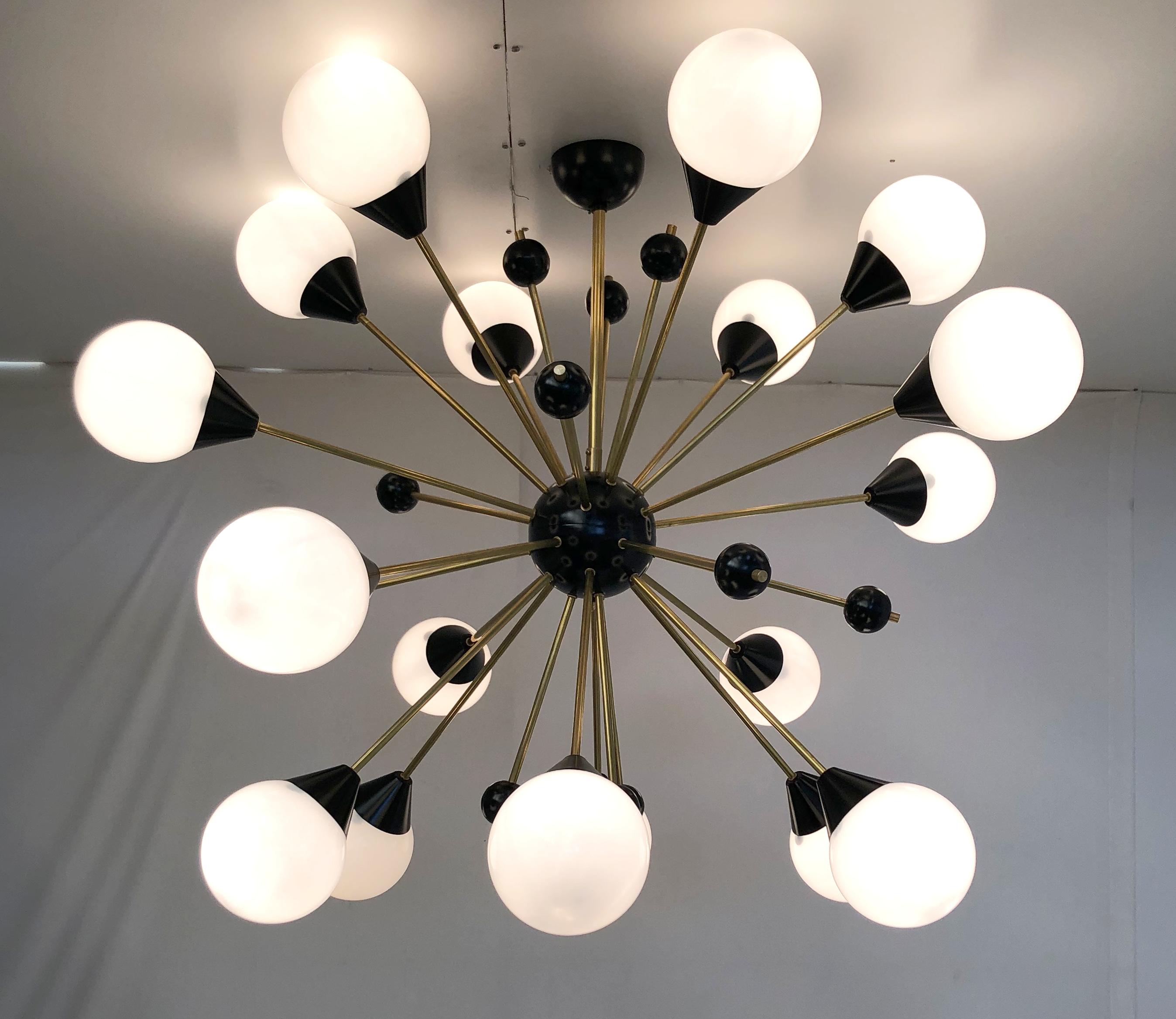 Lustre Sputnik italien de style milieu du siècle avec 18 globes en verre de Murano blanc brillant sur des tiges en laiton naturel non laqué, avec de petits globes décoratifs noirs, centre noir et baldaquin au plafond / conçu par Fabio Bergomi pour