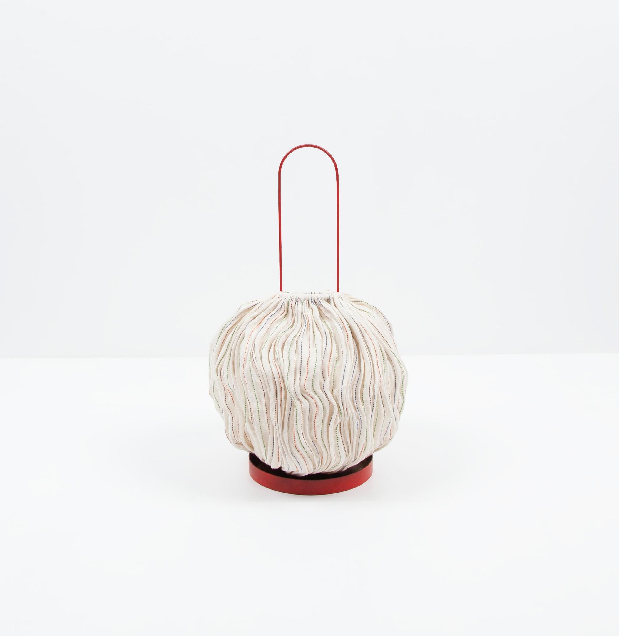The Nebule lamp with a metal base large is part of a lamps series made from handwoven cotton with recycled phone wire by the Ethiopian cooperative ShimenaWeavingFriendships in Arba Minch.

The weaving of recycled wires and cotton results in a soft,