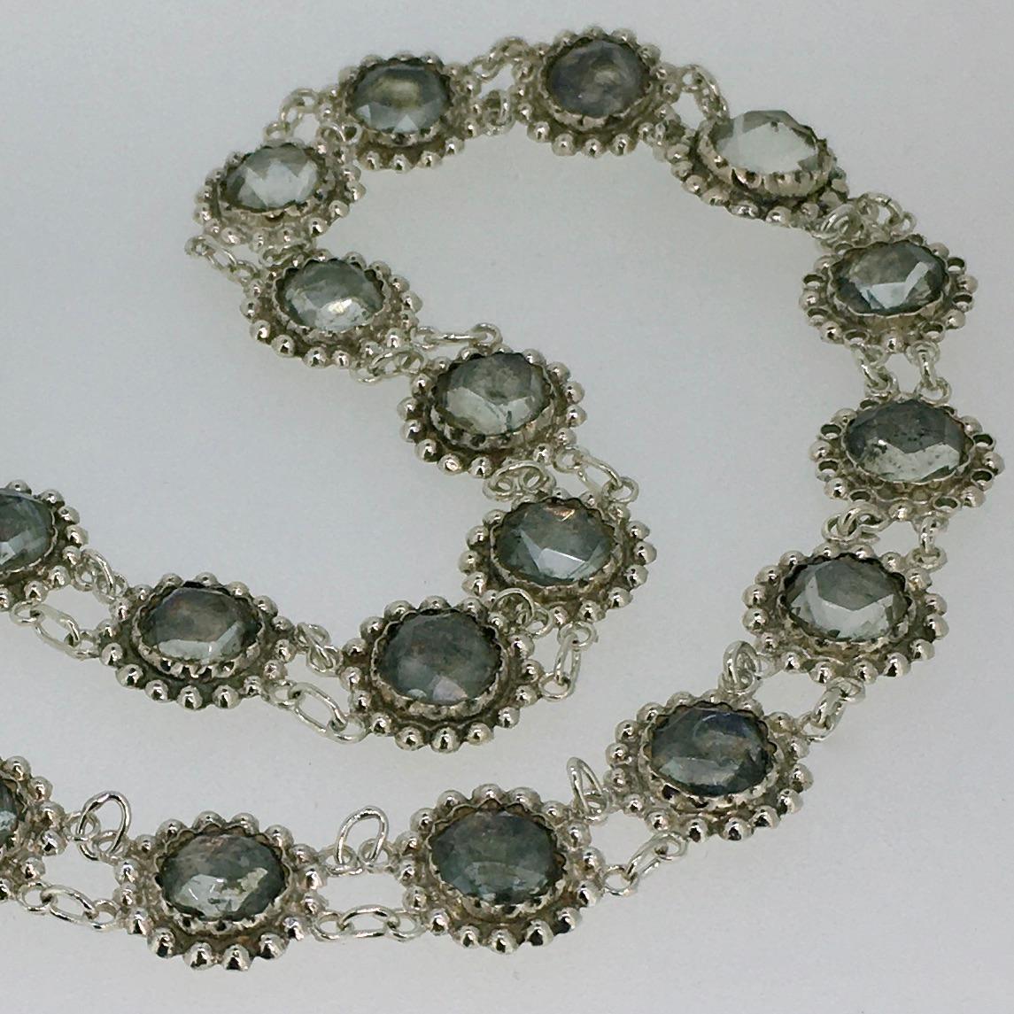 Silver Necklace, set with rose cut Rhinestones, 27 links, integrated lock.

This antique necklace consists of 26 rosette-shaped links set with rose-cut rock crystals. The closure is also completely authentic, which is rare itself.
The colors of the