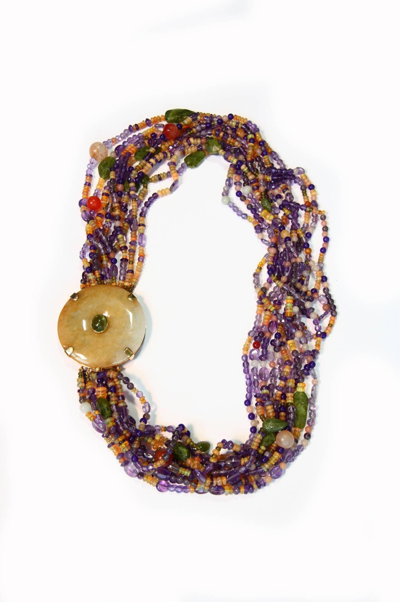 Degradè long necklace total length 31 cm, amethyst, fire opal, tourmaline, vesuvianite, little leaf in green vesuvianite,  big BI in  jade used like a closure, cabochon green tourmaline, 18kt gold gr. 29,00.
All Giulia Colussi jewelry is new and has