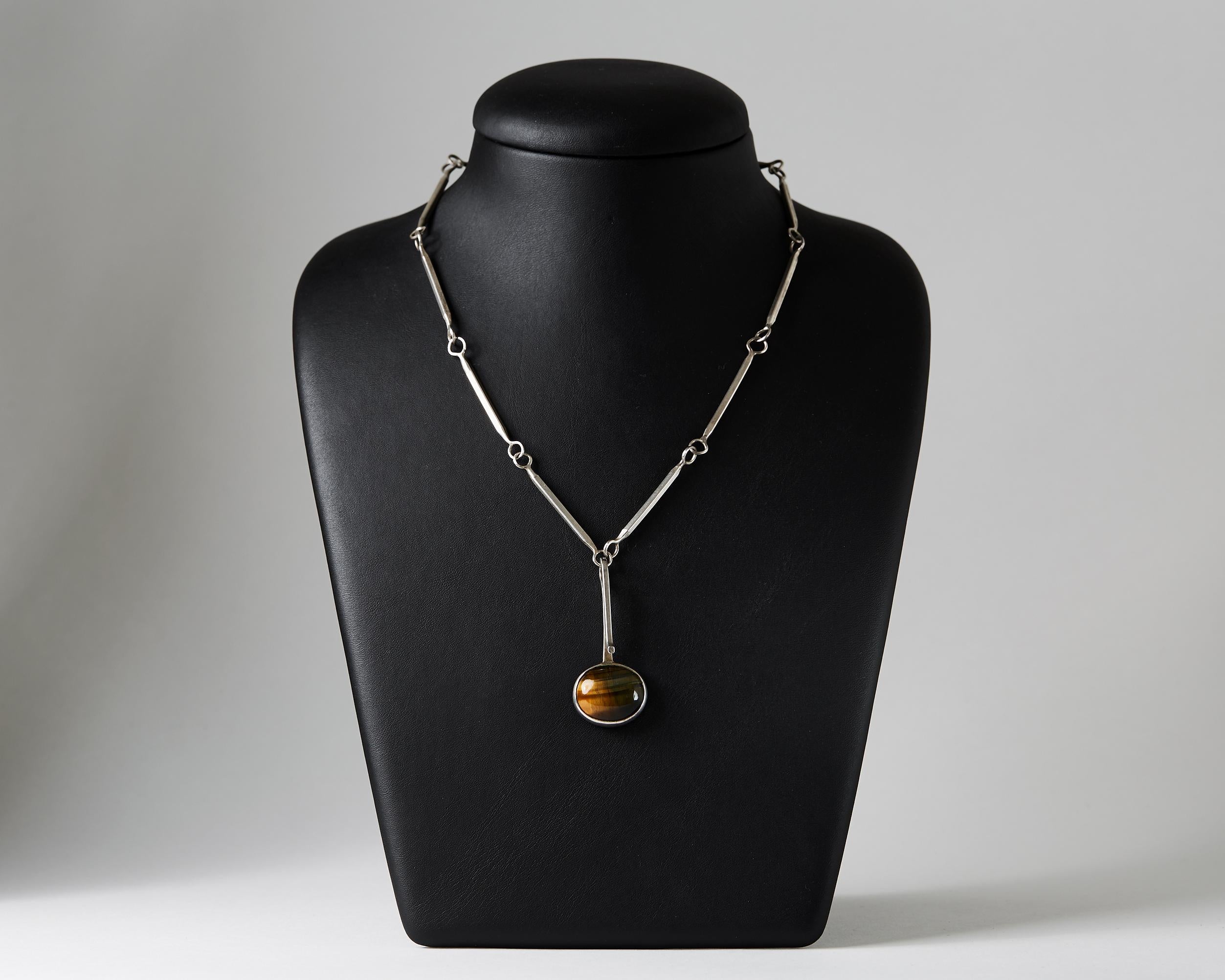 Sterling silver and Tiger's eye.

Length of the chain: 66 cm/ 26''
Length of the pendant. 5 cm/ 2''