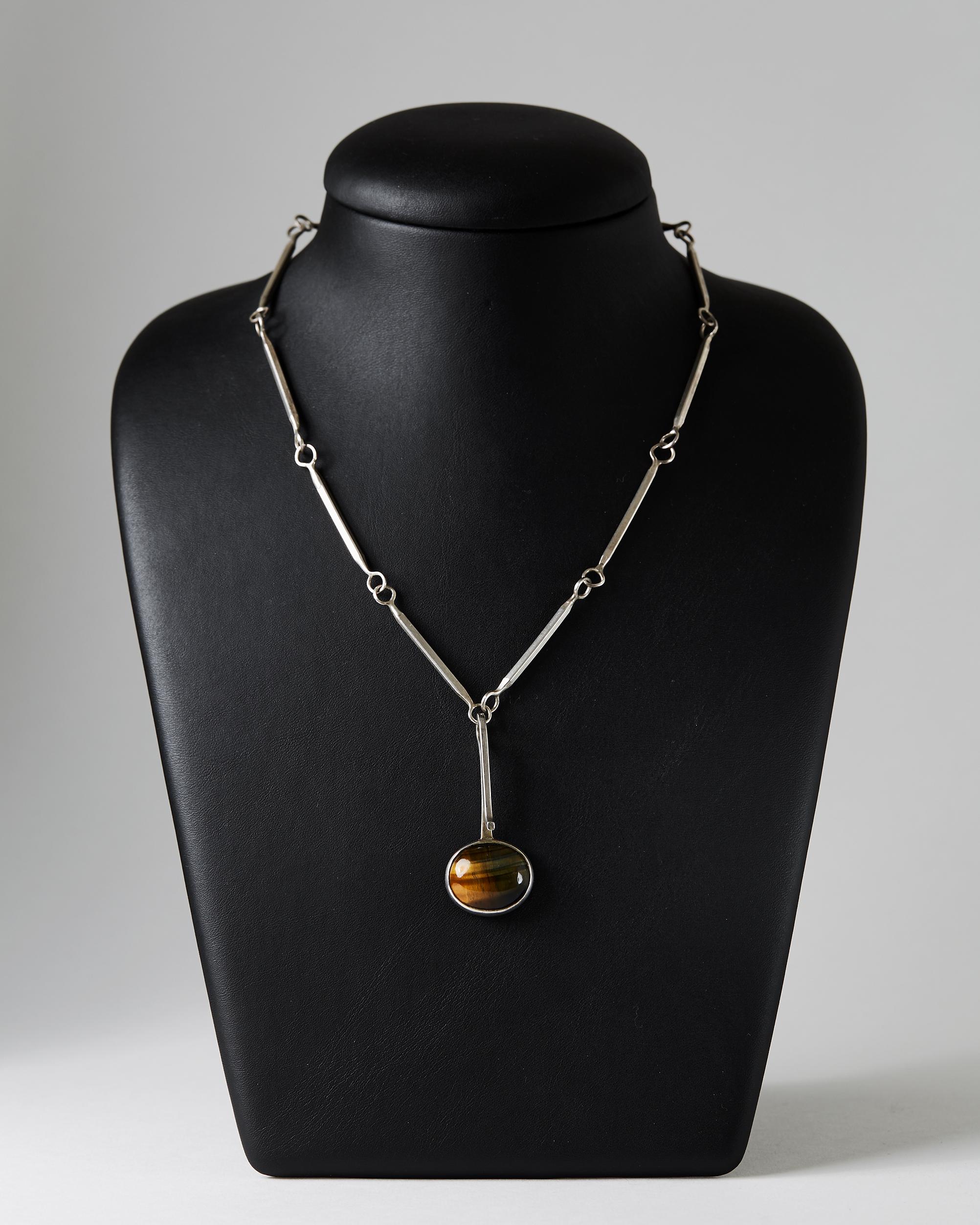 Sterling silver and Tiger's eye.

Length of the chain: 66 cm/ 26''
Length of the pendant. 5 cm/ 2''