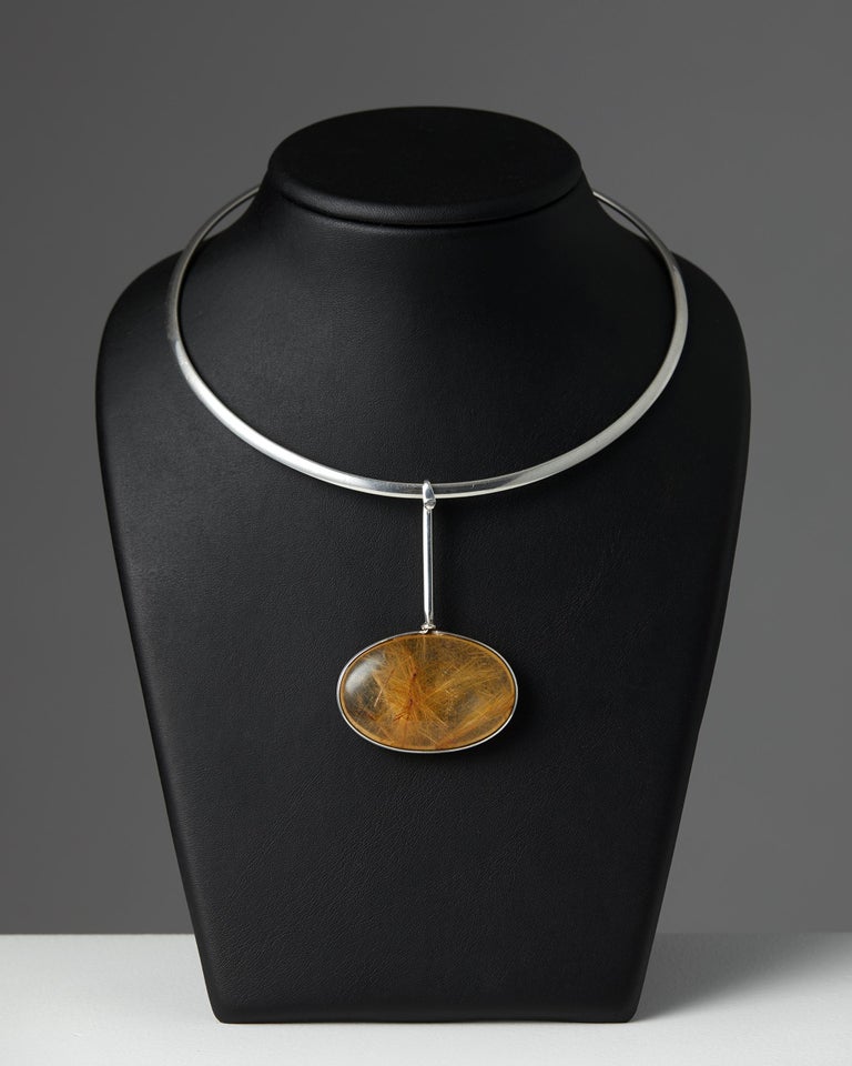 Sterling silver and rutile quartz.

Stamped: Georg Jensen, Denmark, 925 sterling, Torun.

Numbered 247 and 133.